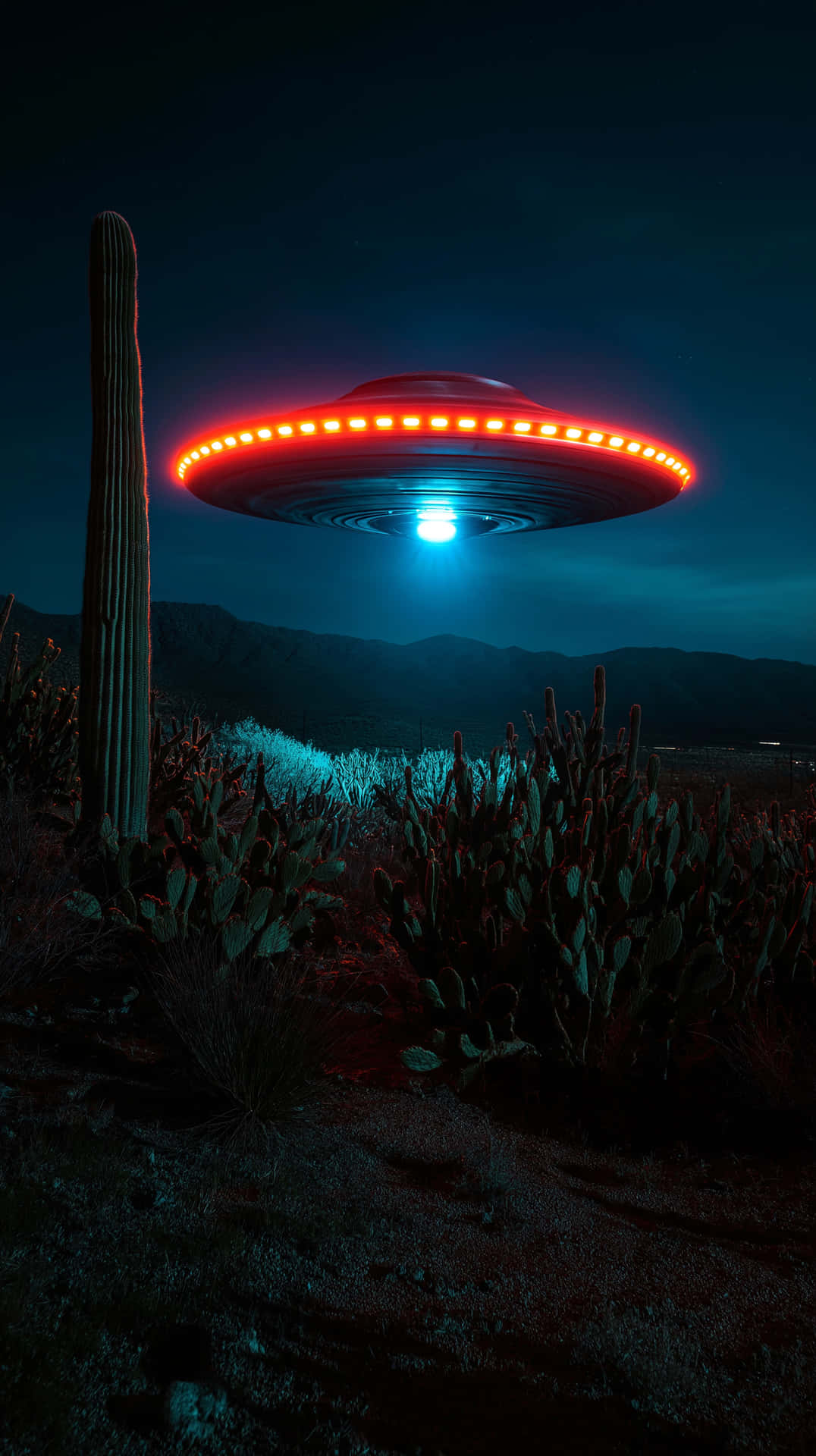 Desert UFO Encounter 壁紙 — 一個發光的紅藍色UFO在黑暗夜空下，盤旋在一個有薩瓜羅仙人掌的沙漠景觀上方。