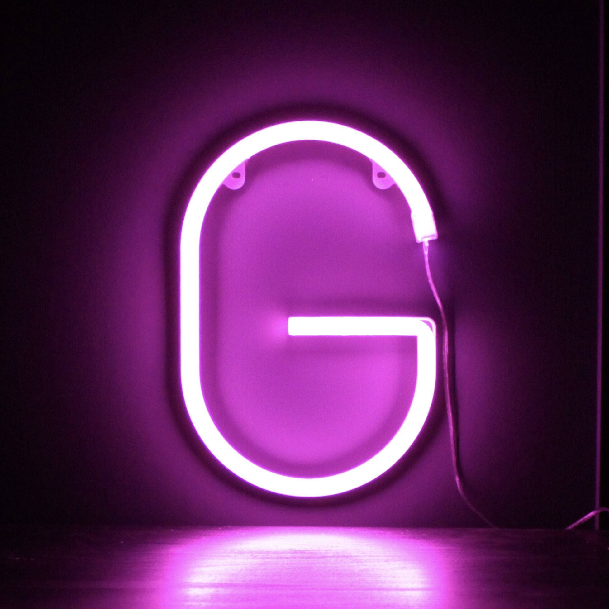 g 桌布 壁紙 — 一個發光的紫色霓虹字母G，在黑暗的牆壁和反光表面上投射出柔和的光芒。