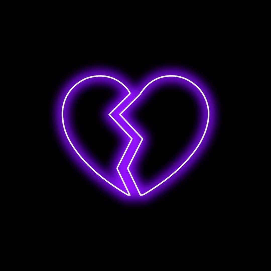 heartbroken 桌布 壁紙 — 一個發光的紫色霓虹心碎成兩半，背景為黑色。