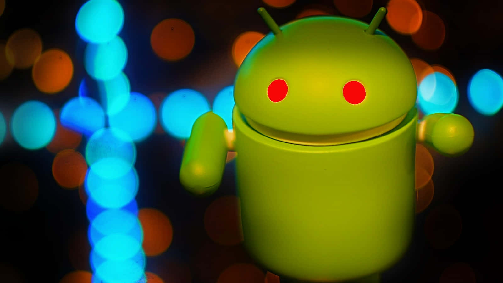 安卓 桌布 壁紙 — 一個發光的綠色Android機器人公仔，在藍色和橙色燈光的鮮豔散景背景前站立。