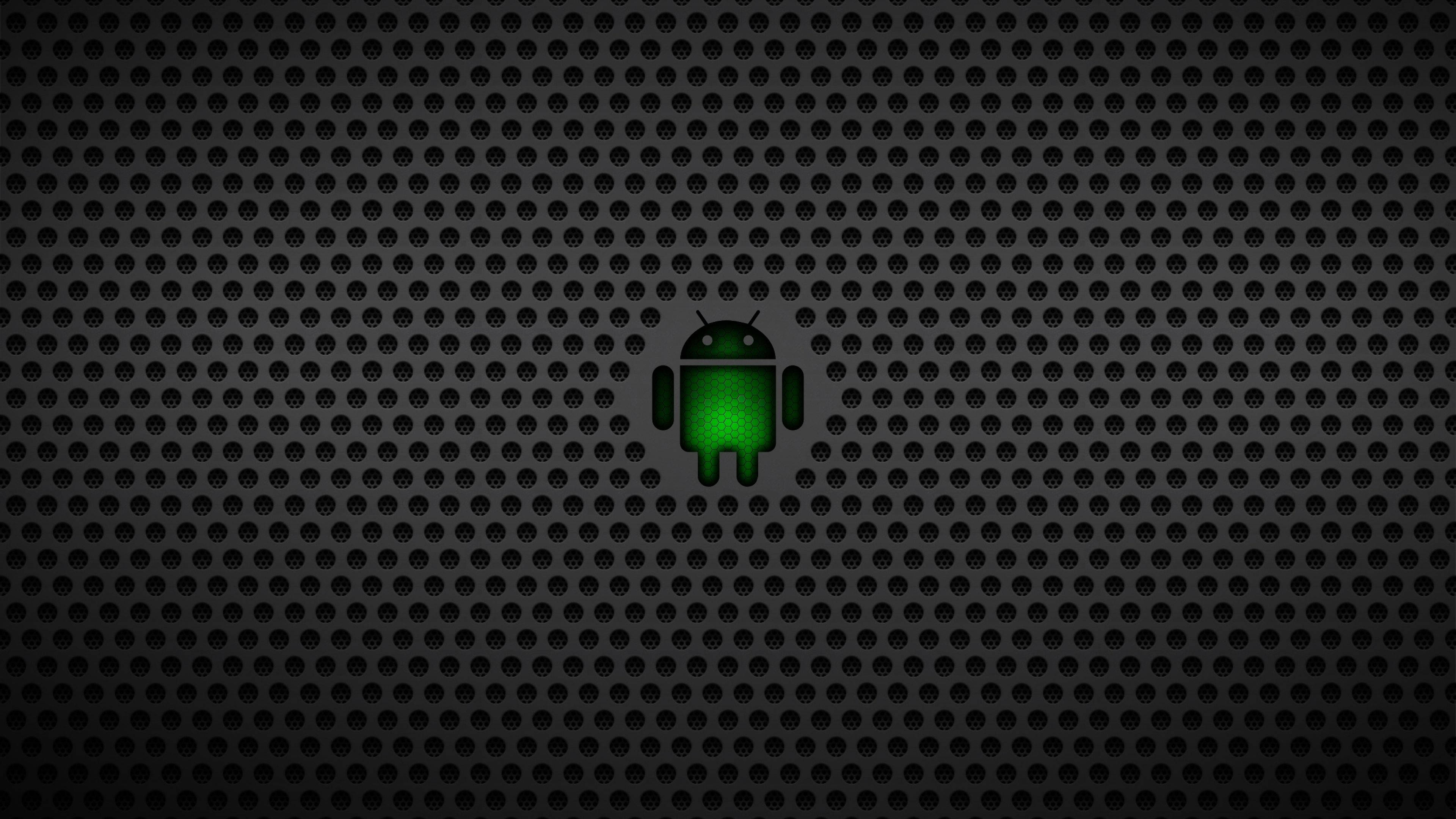 Black Android 桌布 壁紙 — 一個發光的綠色Android機器人圖示，居中放置在深色穿孔金屬背景上。