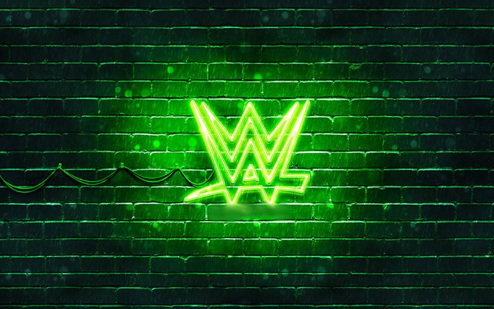WWE 桌布 壁紙 — 一個發光的綠色WWE霓虹燈牌在夜晚照亮了濕漉漉的磚牆，在雨水浸濕的表面上投射出鮮豔的倒影。