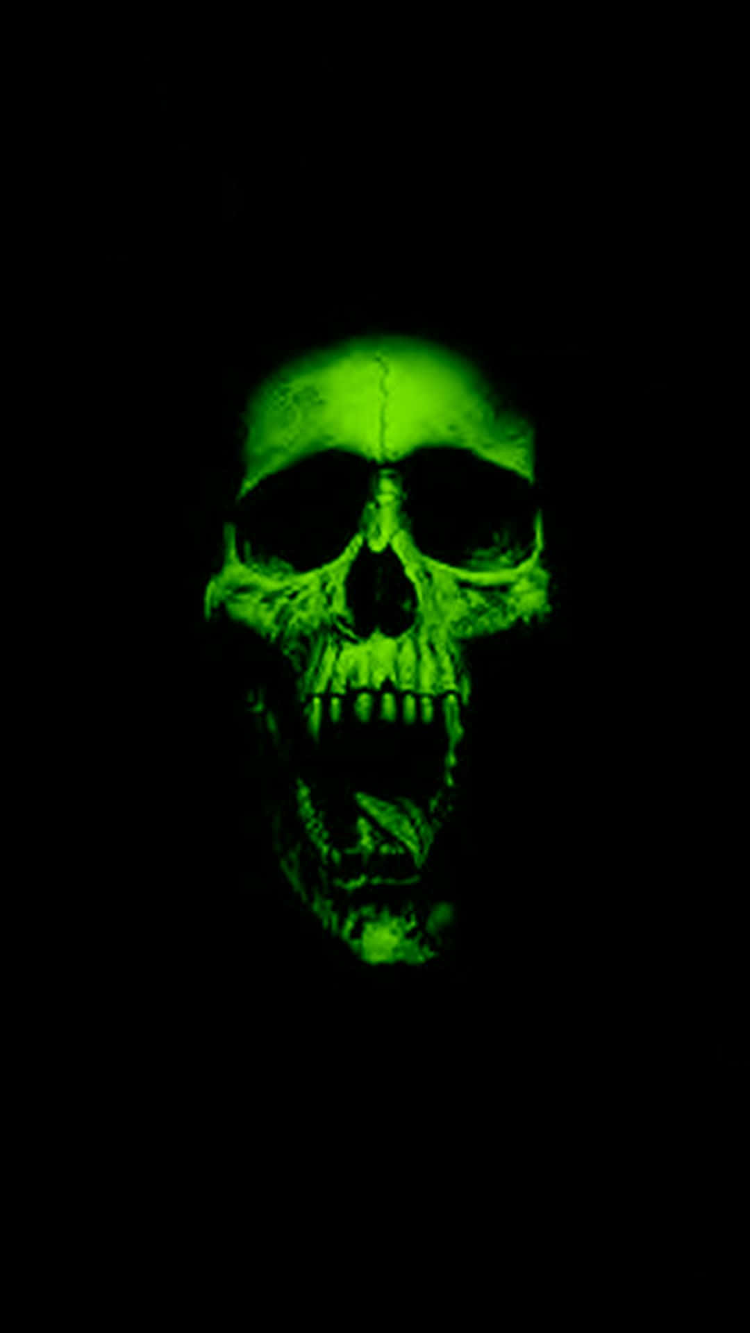 Evil Skull 桌布 壁紙 — 一個發光的綠色人類頭骨，在漆黑的背景下向前凝視，帶有詭異的強度。