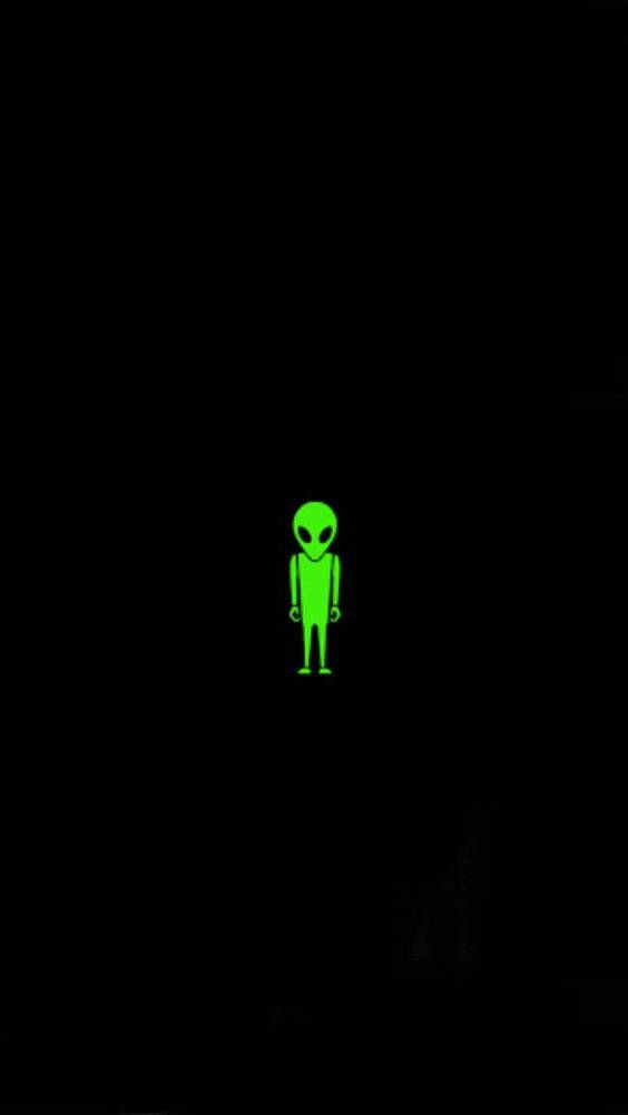 Cool Alien 桌布 壁紙 — 一個發光的綠色外星人身影獨自站在漆黑的背景前。