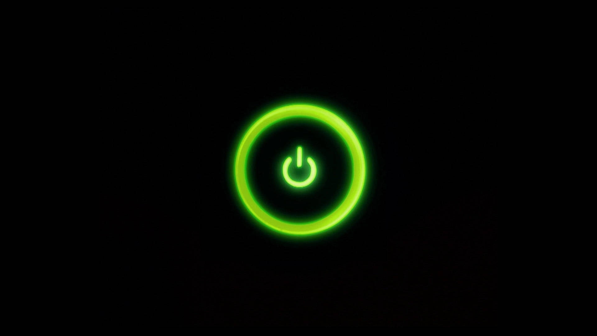 螢光綠 桌布 壁紙 — 一個發光的綠色電源按鈕圖示在純黑色背景上柔和地脈動。