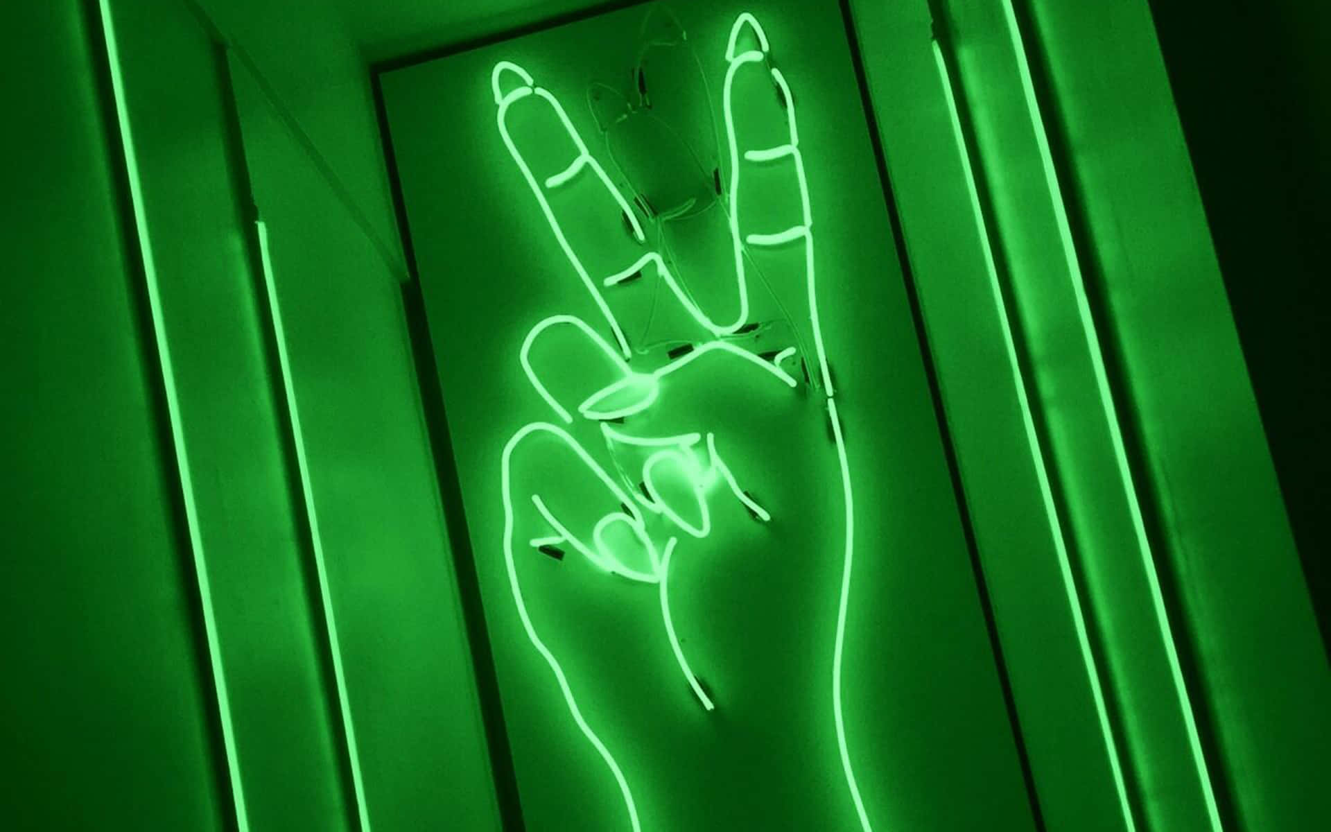 Lime Green Aesthetic 桌布 壁紙 — 一個發光的綠色霓虹燈牌，形狀像一隻手做出和平手勢，由垂直的霓虹燈管框住，背景是深色牆壁。