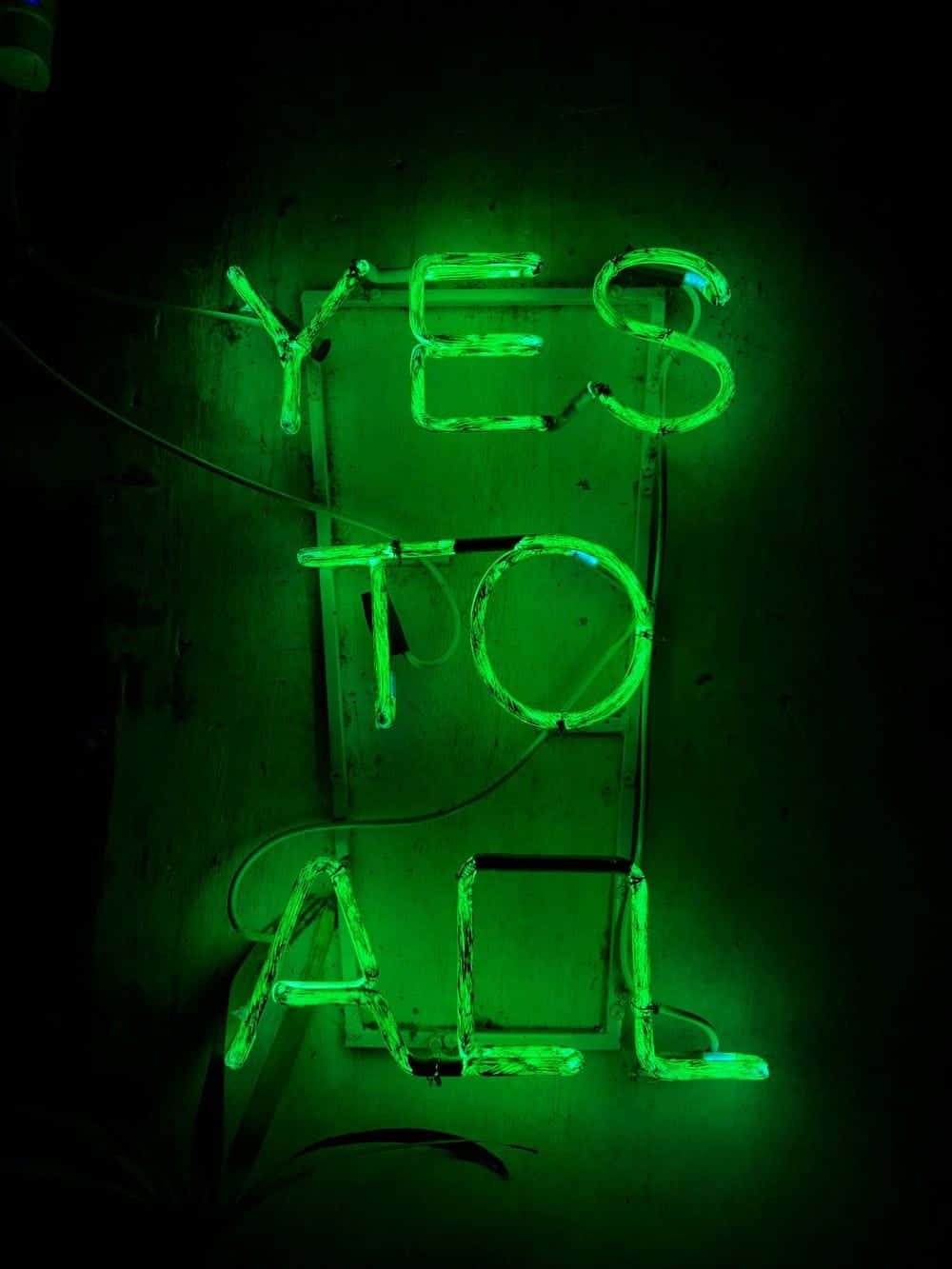 Fluorescent 桌布 壁紙 — 一個發光的綠色霓虹燈牌，拼寫著「YES TO ALL」，在深色紋理牆壁上投射出電光般的光芒。