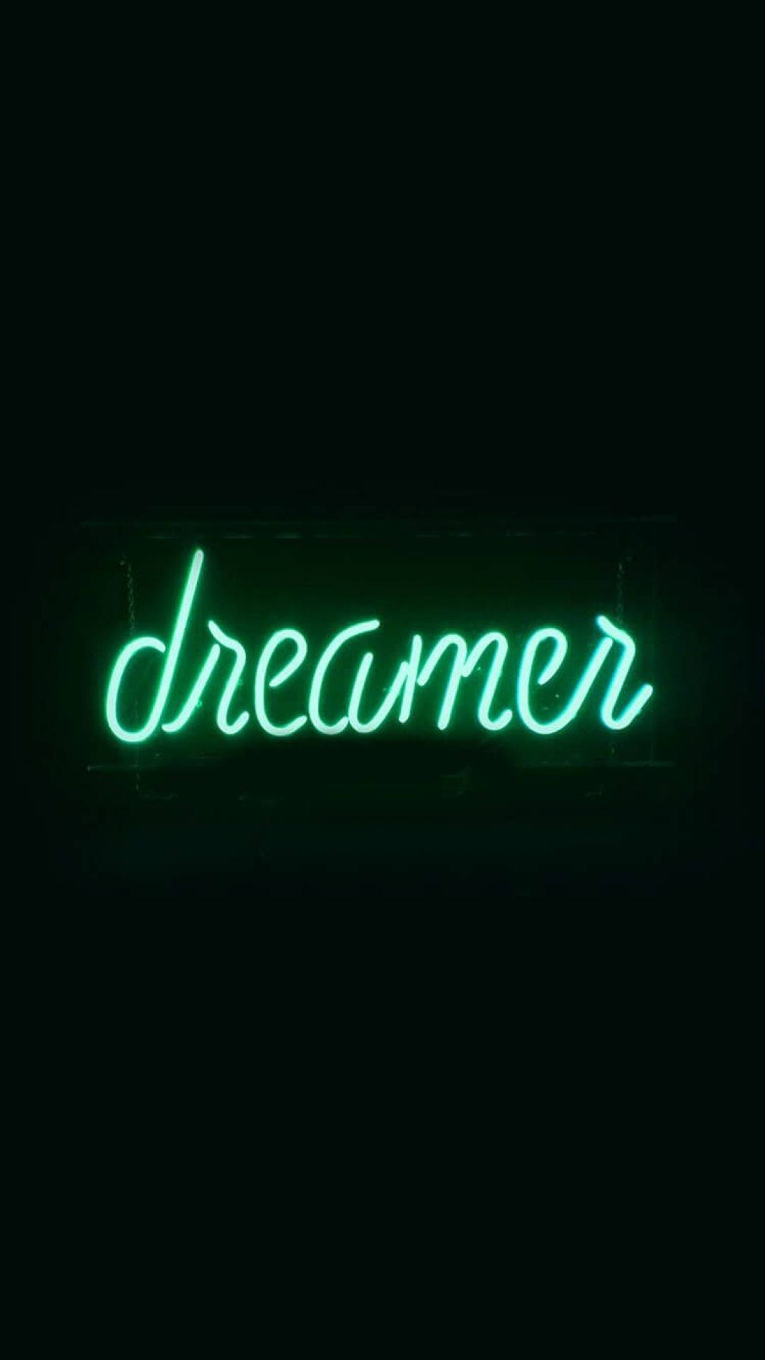 夢幻 桌布 壁紙 — 一個發光的綠色霓虹燈牌，拼寫著dreamer，在漆黑的背景下明亮地閃耀。