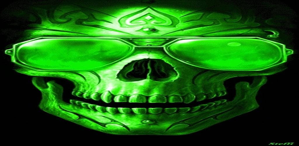 Green Fire Skull 桌布 壁紙 — 一個發光的綠色骷髏頭，戴著超大太陽眼鏡，額頭上有黑桃符號，背景為黑色。