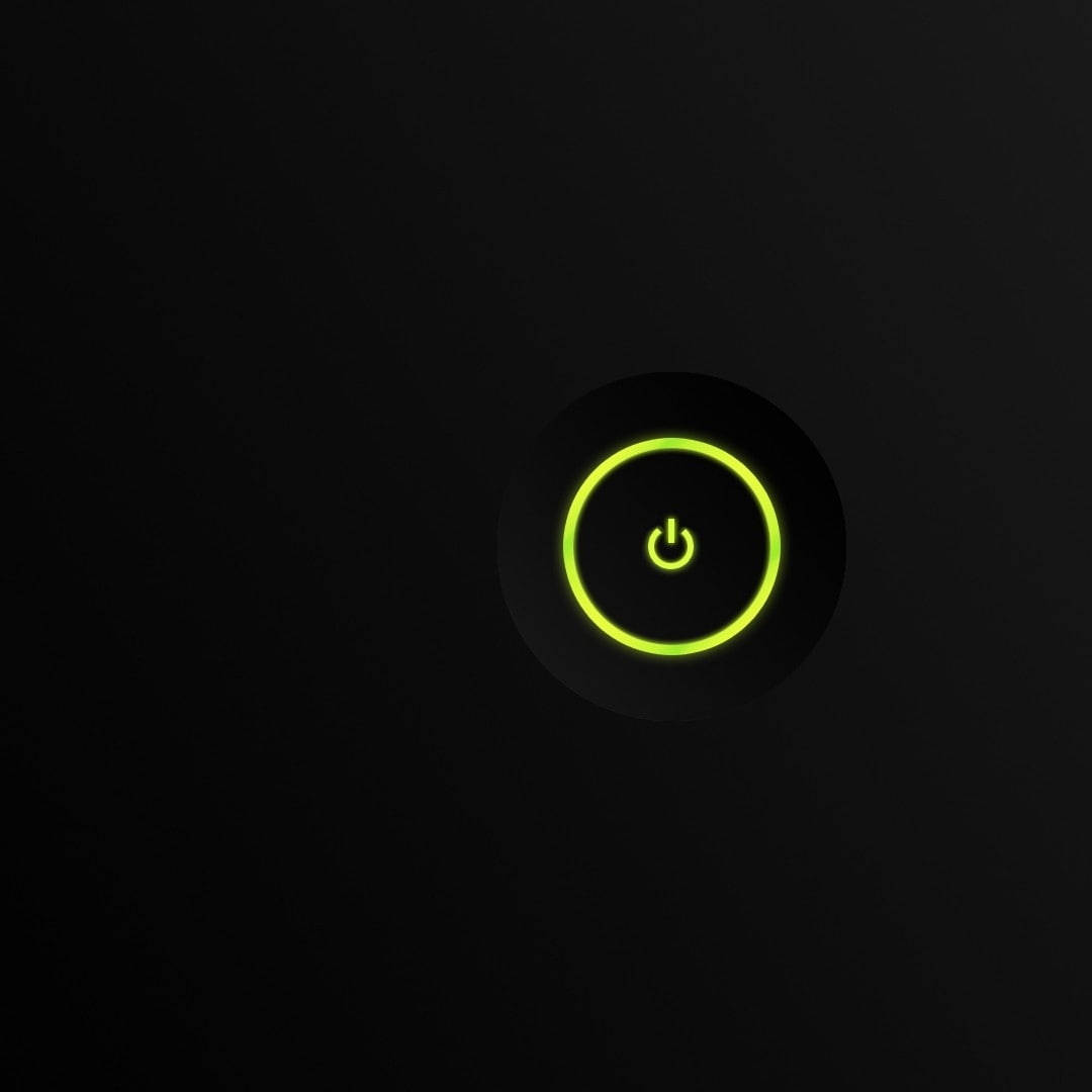 Xbox 桌布 壁紙 — 一個發光的萊姆綠色電源按鈕圖示，置於黑色表面上，散發出柔和的光芒。