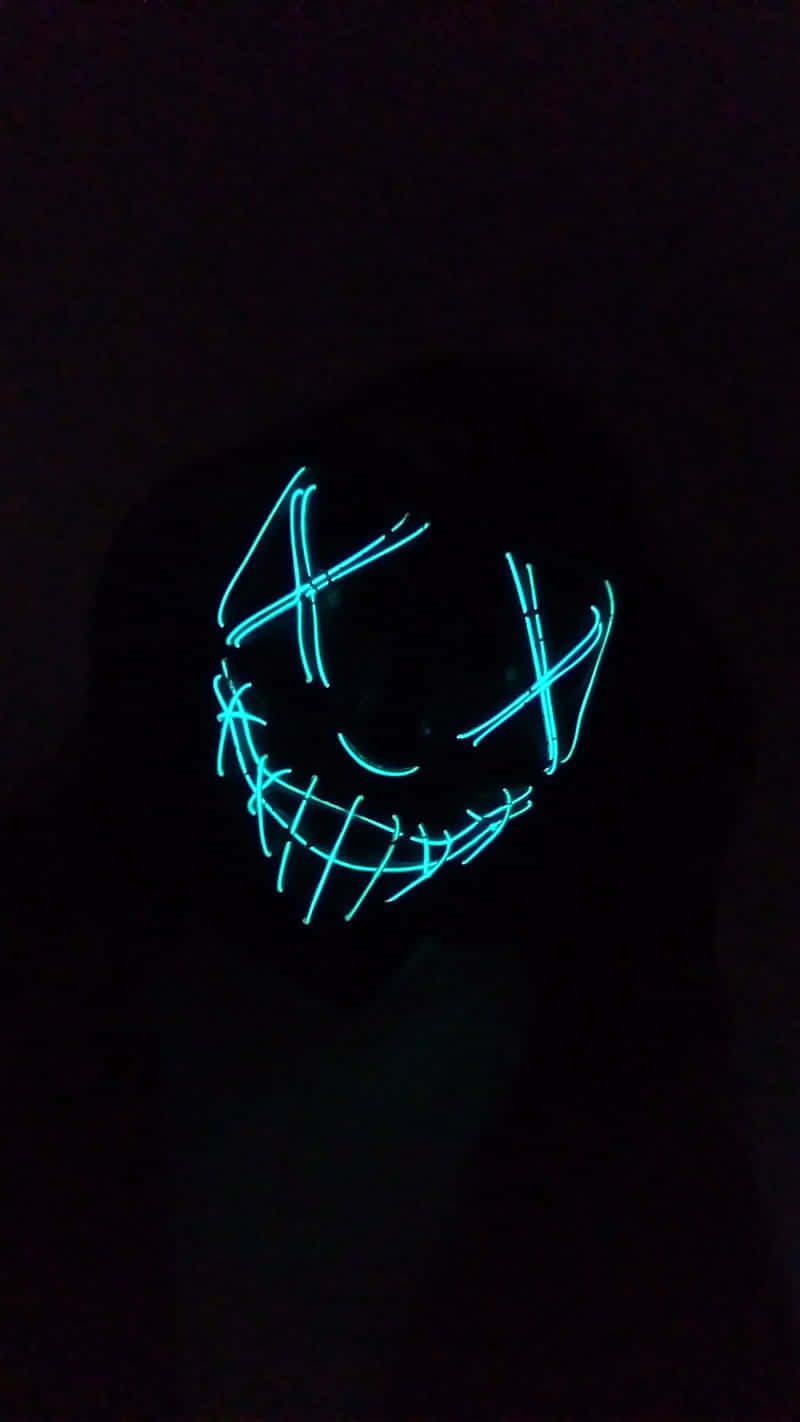 Neon Halloween 桌布 壁紙 — 一個發光的藍色LED面具，帶有縫合的眼睛和寬闊的笑容，照亮了黑暗的背景。