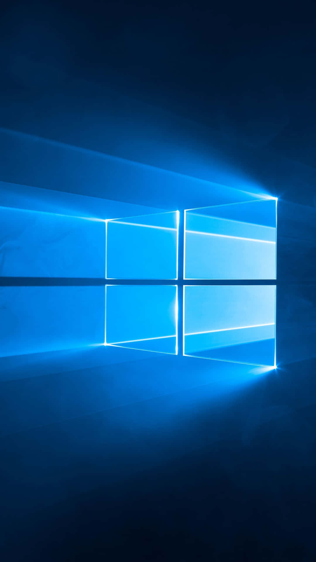 一個發光的藍色Windows標誌在黑暗空間中散發光芒。 — Microsoft 壁紙