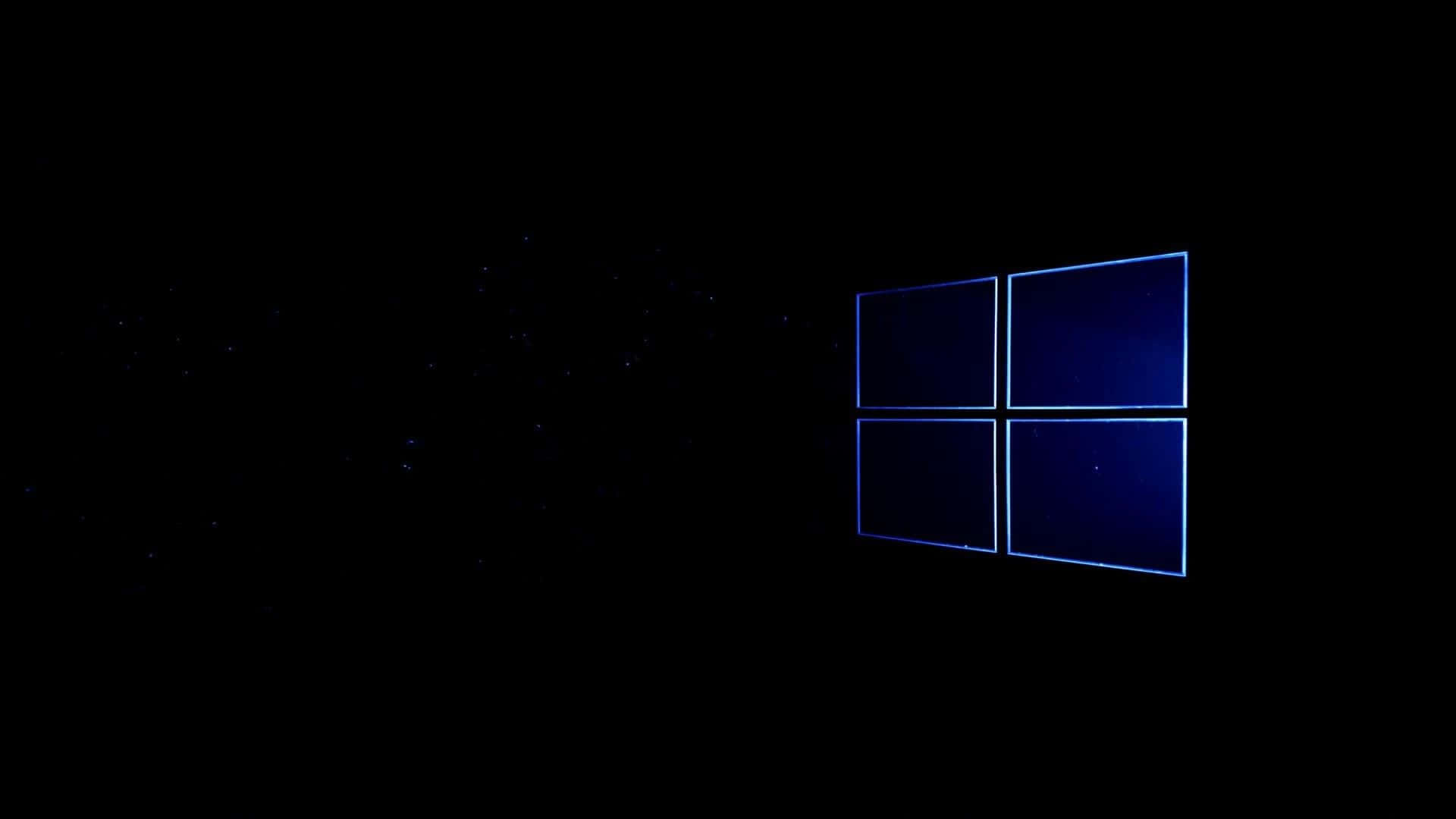 Black Windows 桌布 壁紙 — 一個發光的藍色Windows標誌漂浮在佈滿星星的黑色虛空中，在宇宙黑暗中投射出數位光芒。