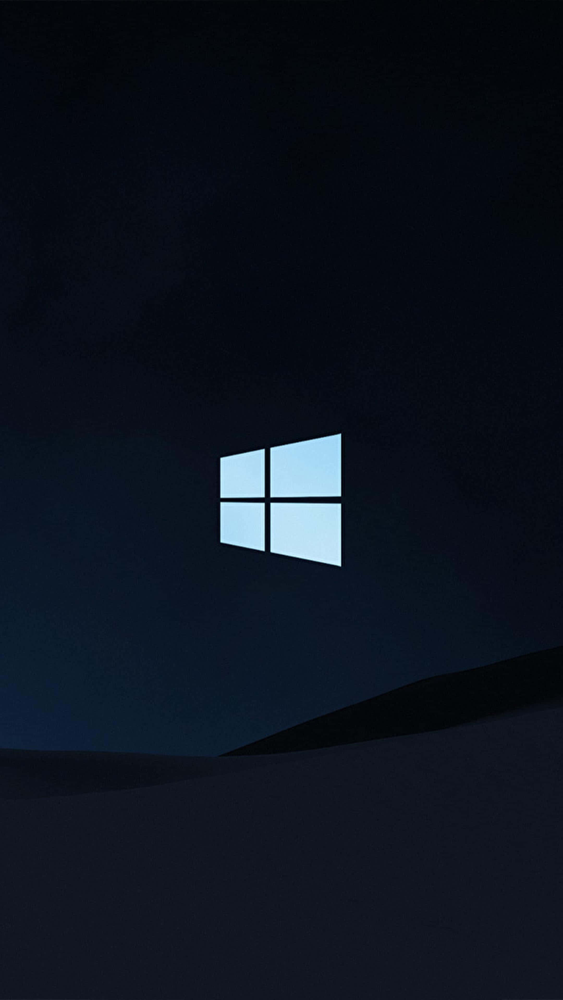 Windows 10 桌布 壁紙 — 一個發光的藍色Windows標誌漂浮在黑暗的夜空中，位於一個陰影籠罩的山丘之上。