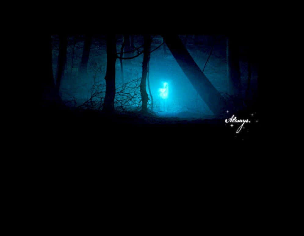 Patronus 桌布 壁紙 — 一個發光的藍色人形身影，站在霧氣瀰漫的黑暗森林中，四周是剪影般的樹木，背景是夜空。