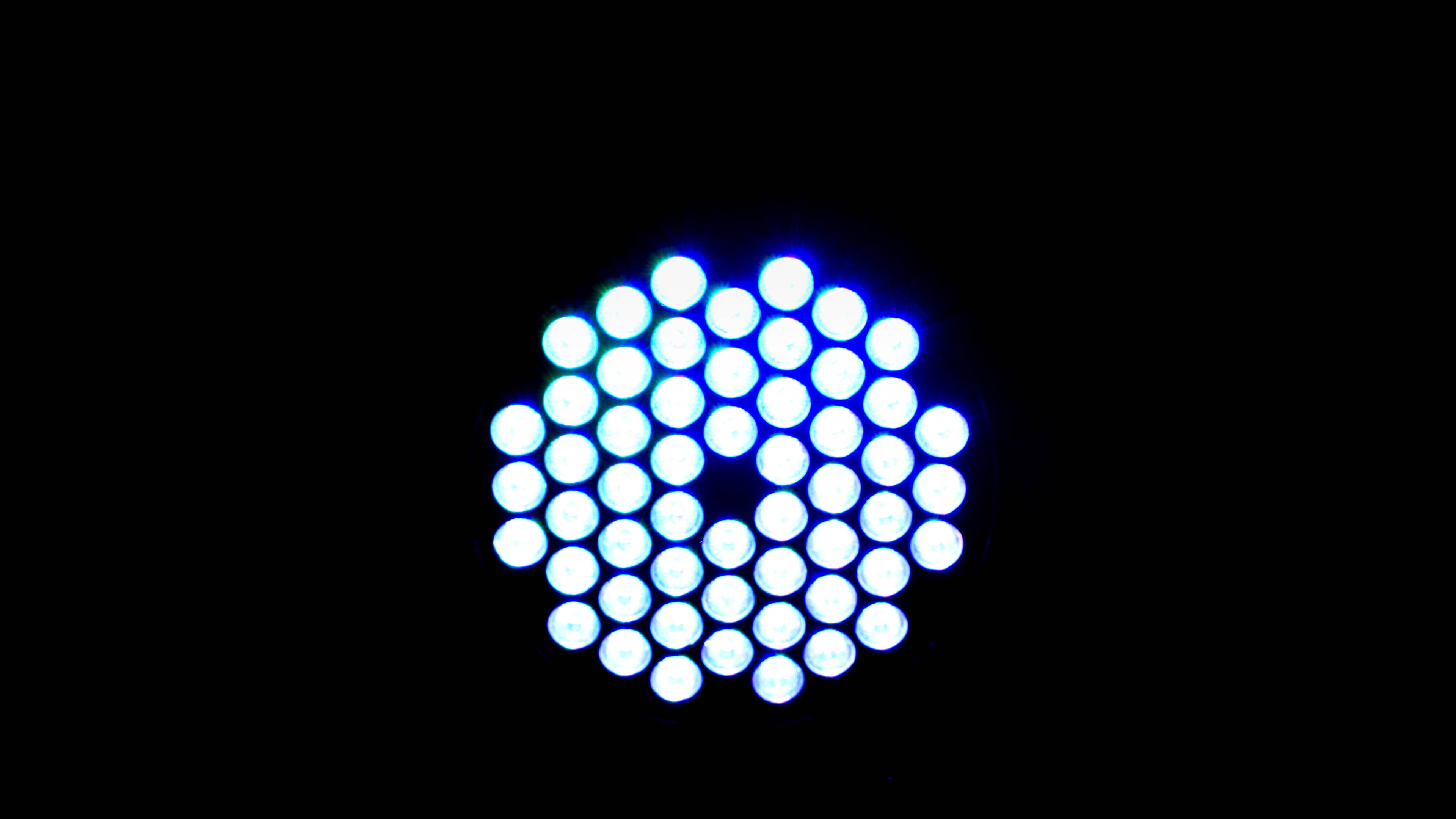 AMOLED 4K 桌布 壁紙 — 一個發光的藍色圓形LED燈陣列在漆黑背景上脈動。