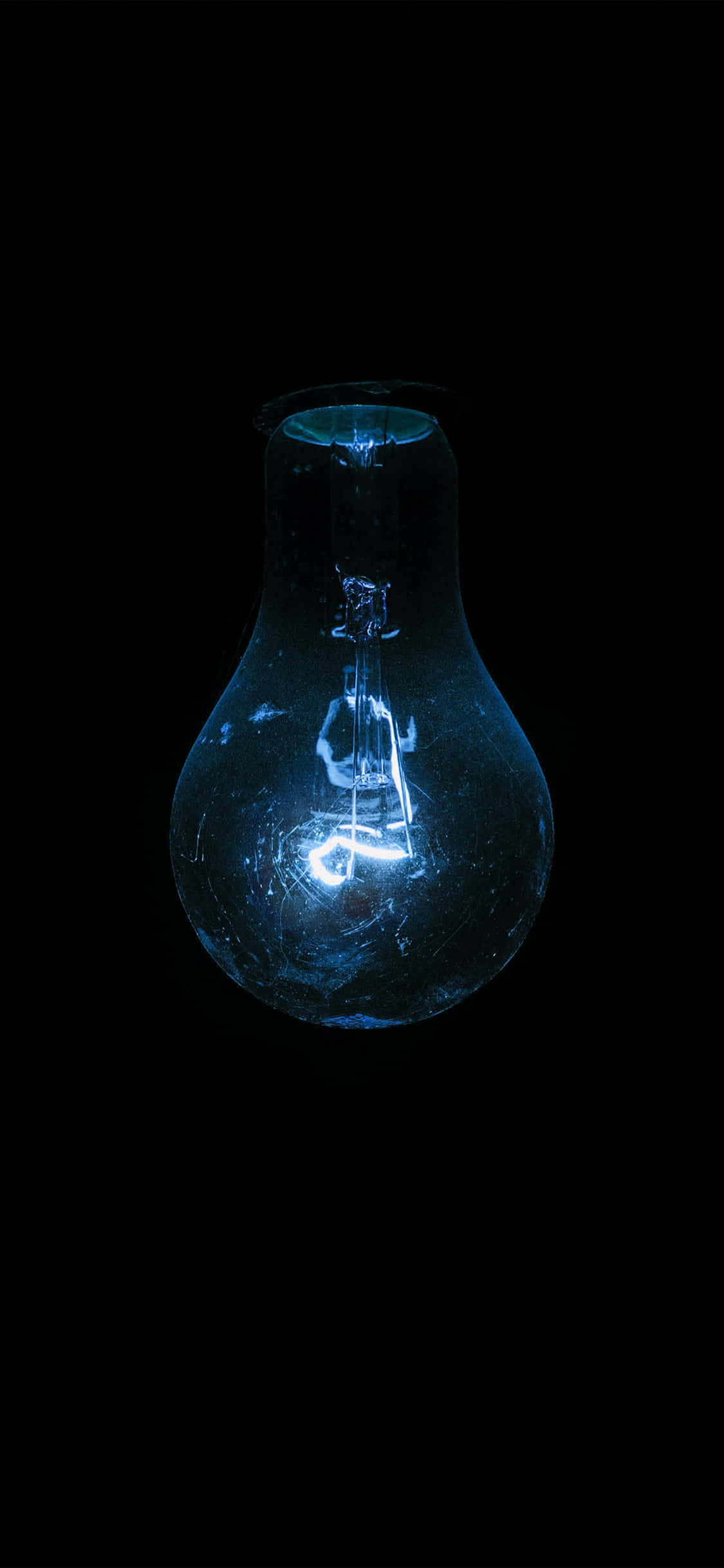 Blue Led 桌布 壁紙 — 一個發光的藍色復古燈泡，帶有可見的燈絲，在純黑色背景上閃耀。