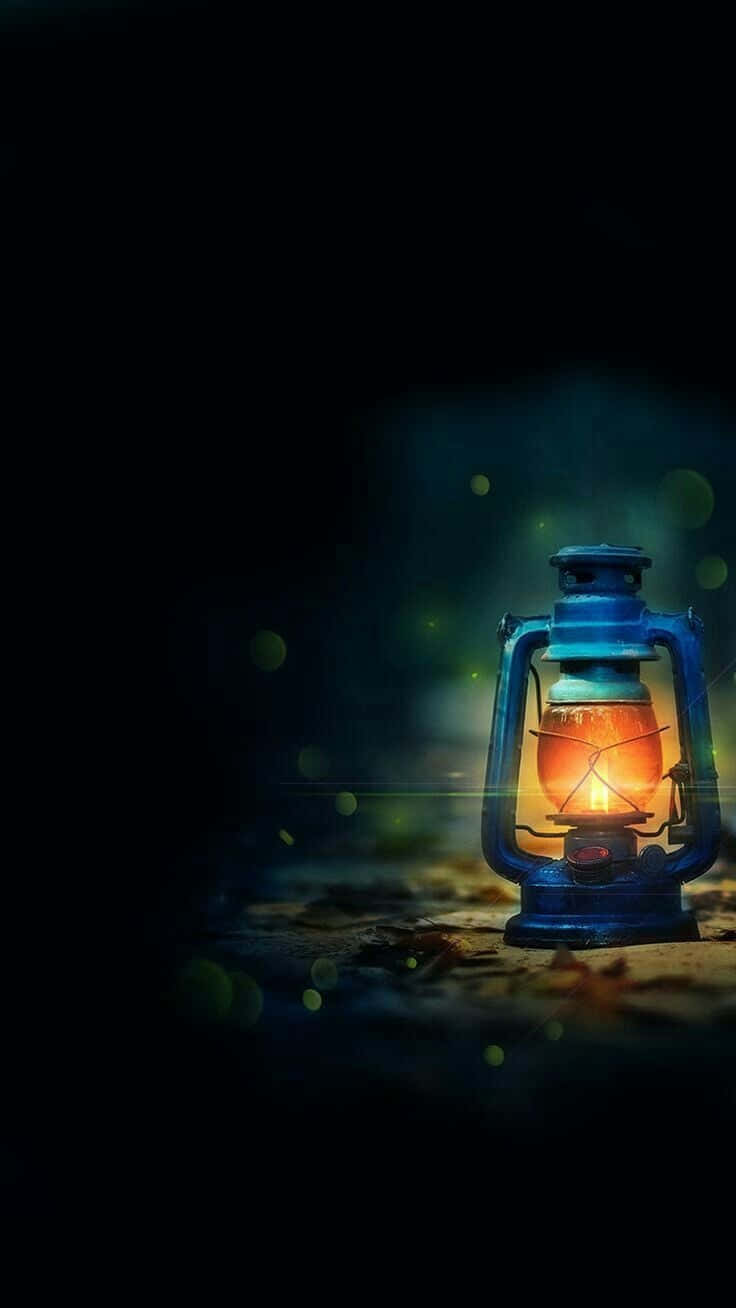 Gambar 桌布 壁紙 — 一個發光的藍色燈籠在黑暗的夜晚背景下投射出溫暖的光芒，帶有柔和的綠色散景效果。