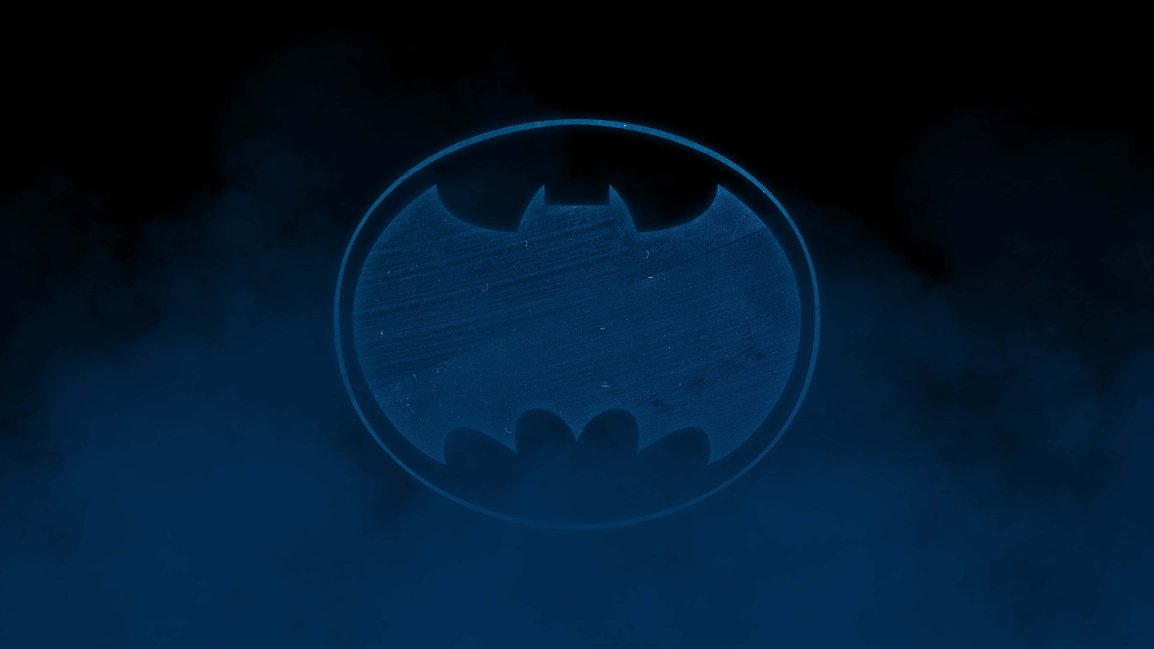 Batman The Dark Knight Returns 桌布 壁紙 — 一個發光的藍色蝙蝠標誌從旋轉的迷霧中浮現，背景為深色。