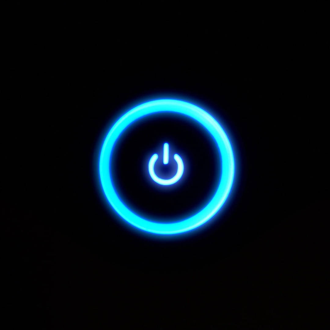 Xbox 桌布 壁紙 — 一個發光的藍色電源按鈕圖示在純黑色背景上柔和地散發光芒。
