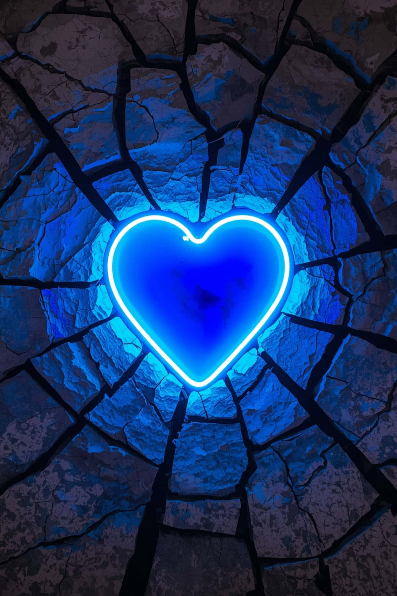 Neon Heart Surrounded by Cracked Stone 壁紙 — 一個發光的藍色霓虹心臟穿過裂開的石頭表面明亮地閃耀，投下深深的陰影。