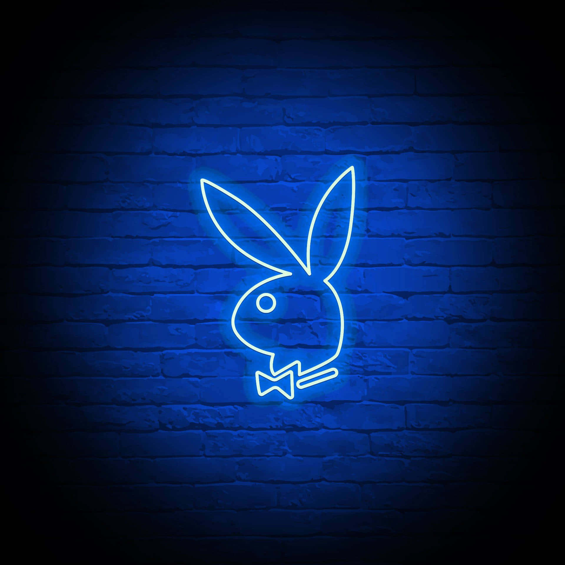 Playboy Aesthetic 桌布 壁紙 — 一個發光的藍色霓虹燈Playboy兔子標誌在黑暗的磚牆上閃耀，營造出憂鬱的城市夜景。