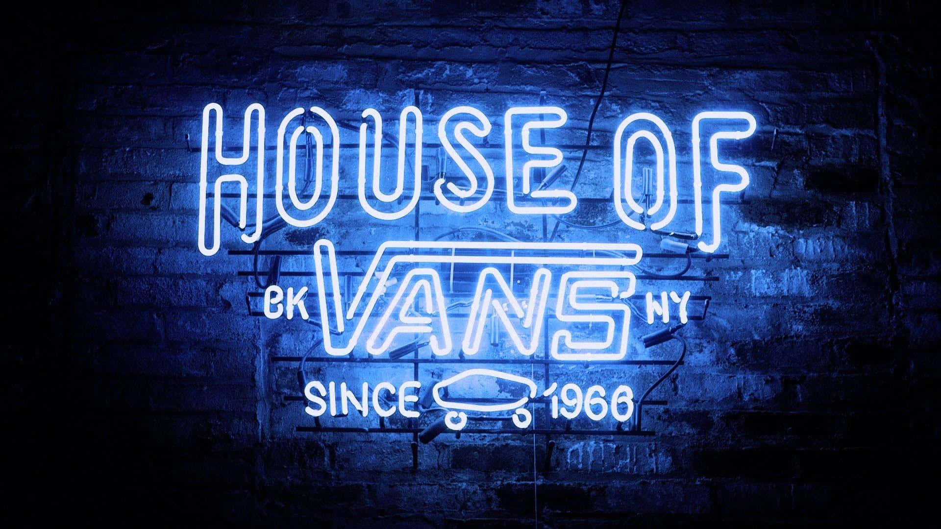 桌布 壁紙 — 一個發光的藍色霓虹燈牌，上面寫著「HOUSE OF VANS NY SINCE 1966」，照亮了帶有滑板圖案的深色磚牆。