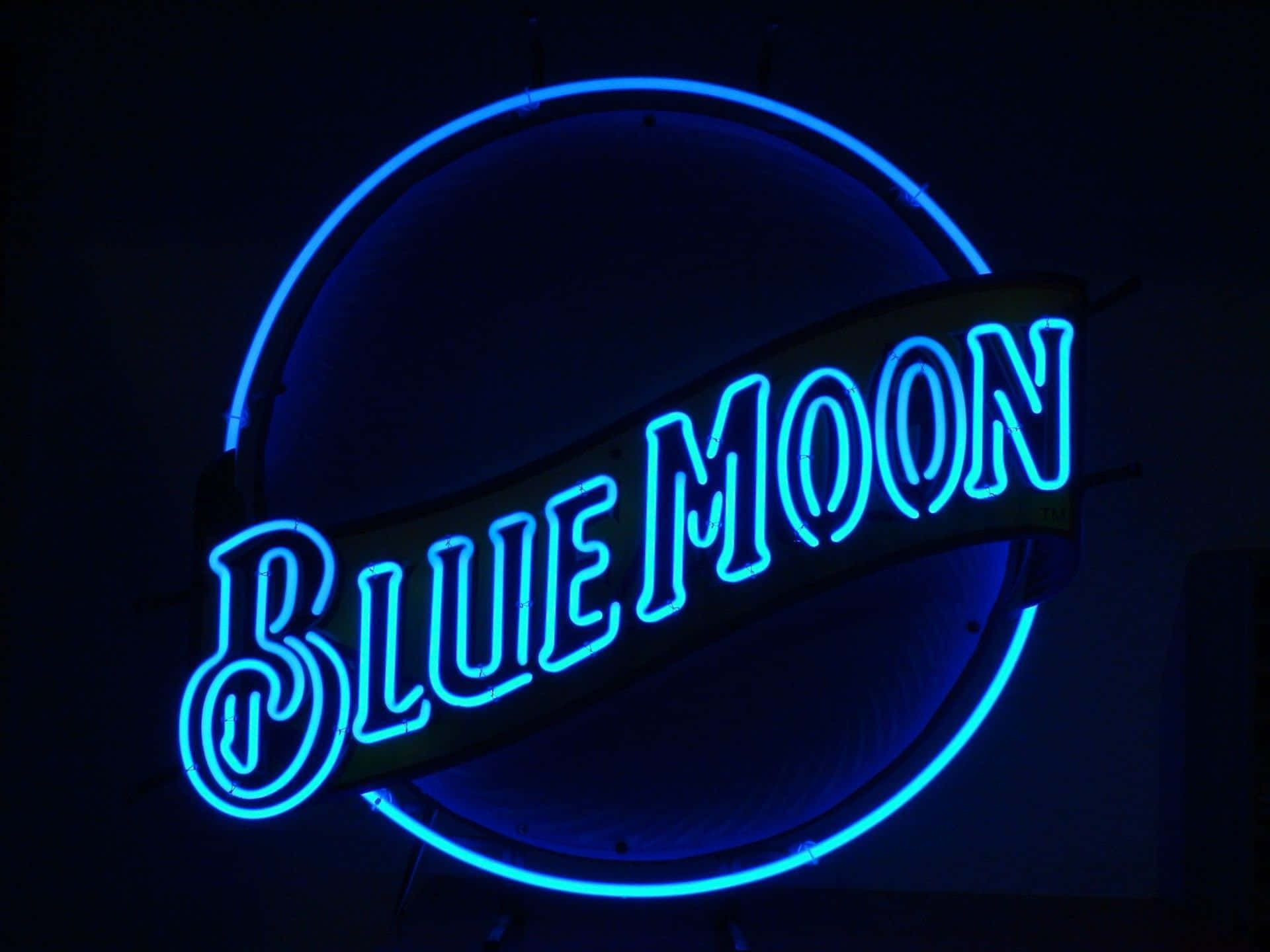 霓虹 桌布 壁紙 — 一個發光的藍色霓虹燈牌，上面寫著 Blue Moon，位於圓形框架內，背景為深色。