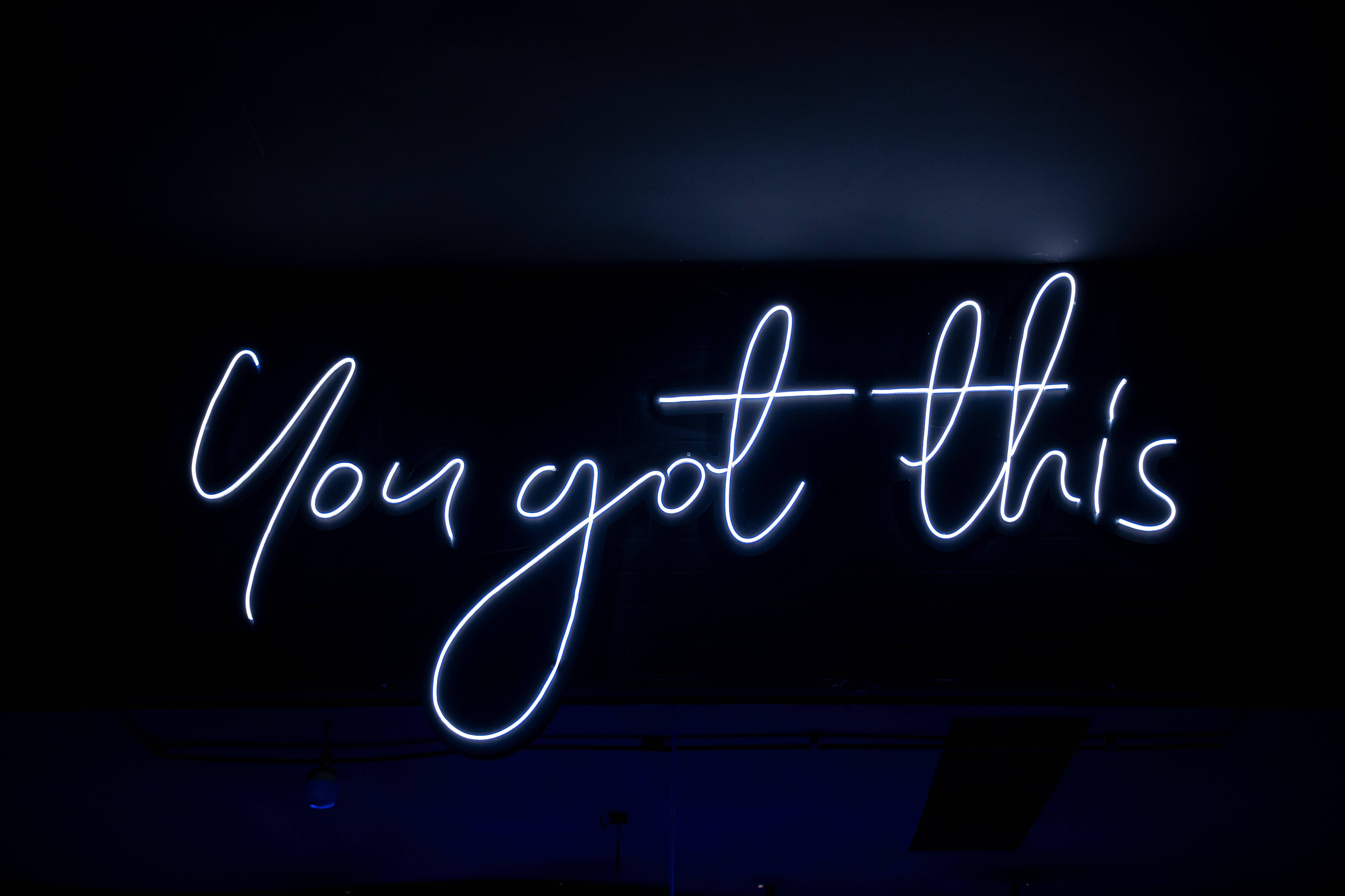 4K 霓虹 桌布 壁紙 — 一個發光的藍色霓虹燈牌，上面寫著「You got this」，背景為深色，帶有微妙的環境照明。