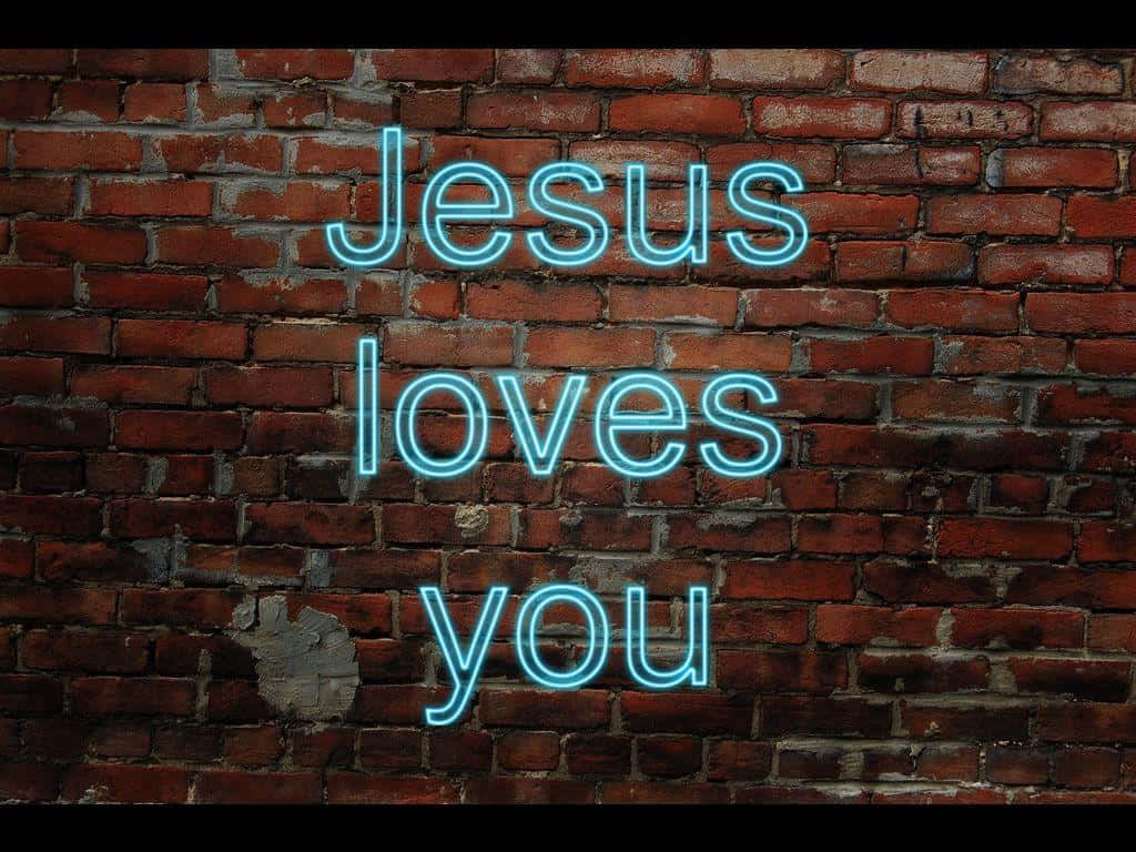 桌布 壁紙 — 一個發光的藍色霓虹燈牌，上面寫著 Jesus loves you，安裝在風化的紅磚牆上。