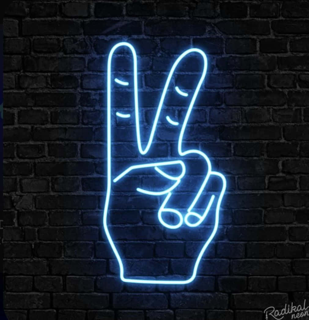Blue Neon Lights 桌布 壁紙 — 一個發光的藍色霓虹燈牌，形狀像和平手勢，在夜間照亮了深色磚牆。