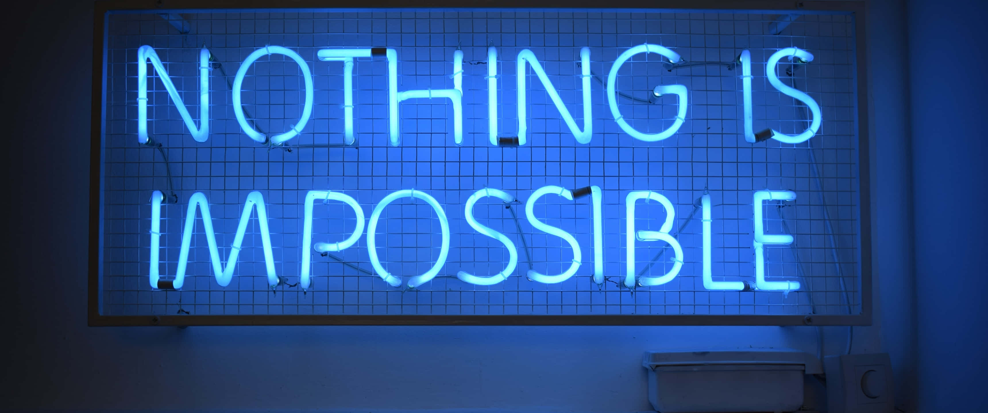 Blue Neon Lights 桌布 壁紙 — 一個發光的藍色霓虹燈牌寫著 nothing is impossible，安裝在暗牆上的網格上。