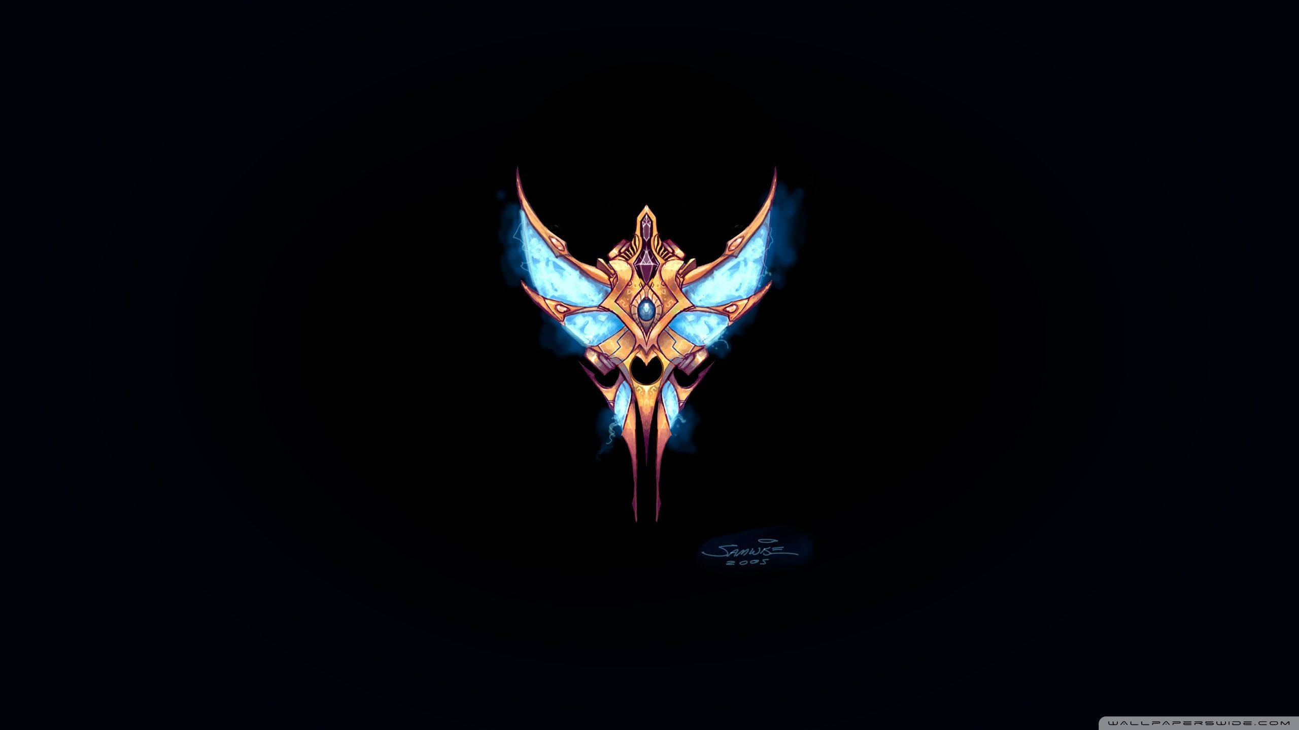 Starcraft 桌布 壁紙 — 一個發光的裝飾性頭骨，帶有藍色翅膀和金色點綴，在黑色背景上閃耀。