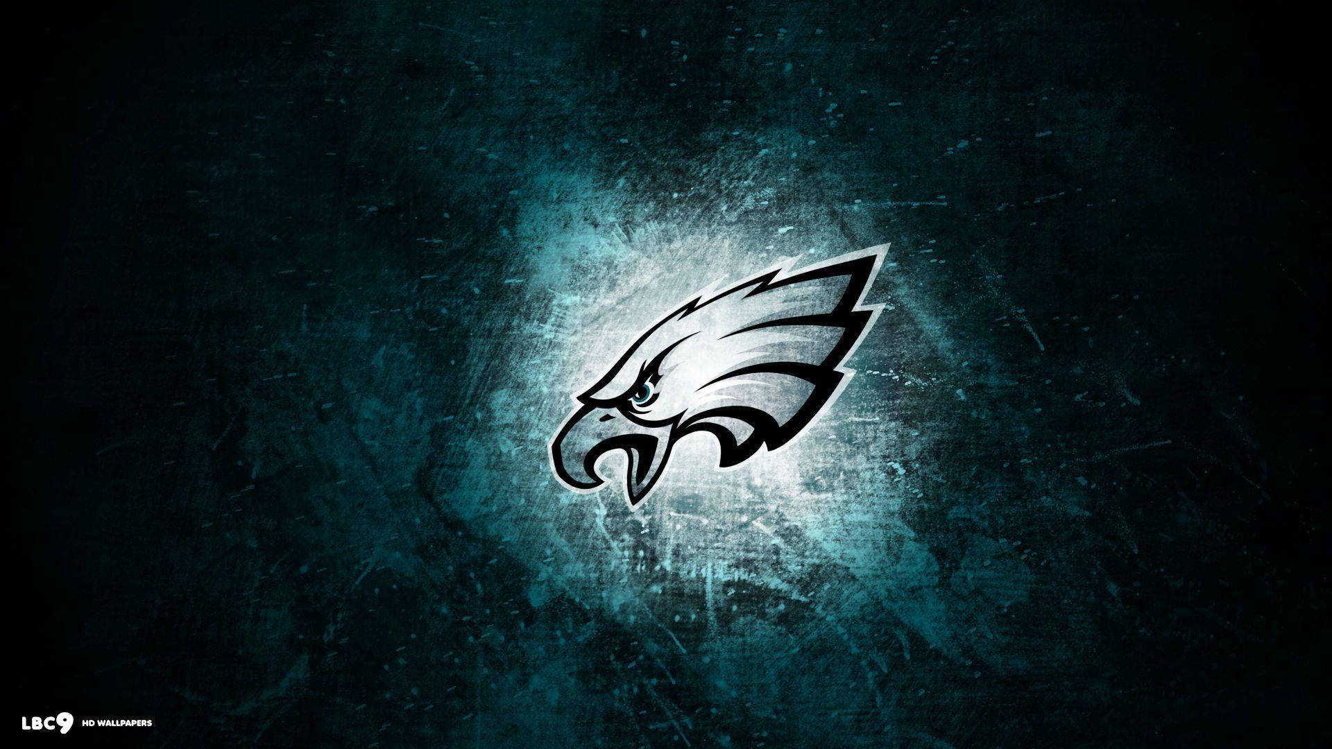 NFL Teams 桌布 壁紙 — 一個發光的費城老鷹隊標誌從帶有粗糙刮痕的紋理青綠色和黑色背景中散發出來。