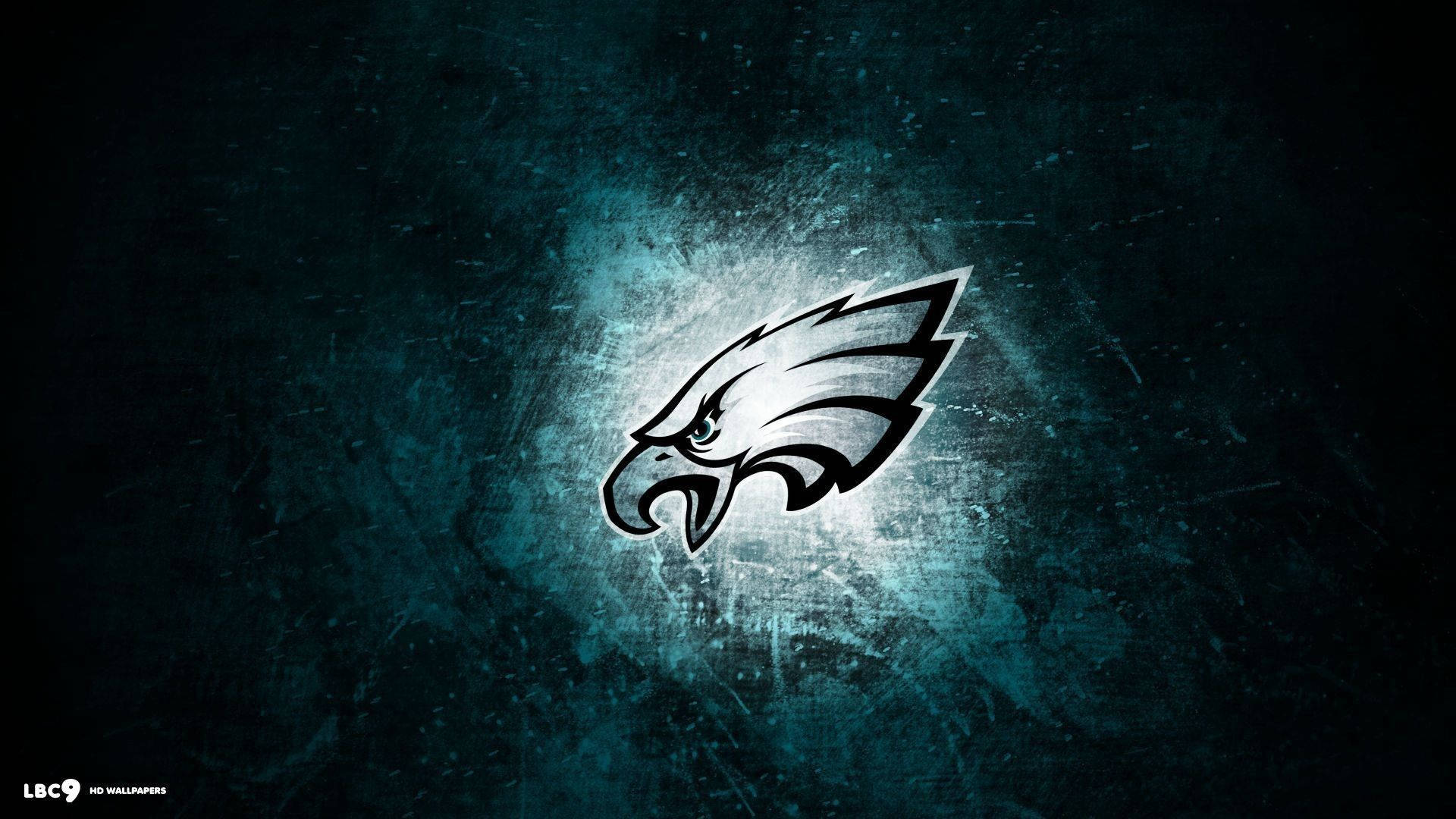 NFL Teams 桌布 壁紙 — 一個發光的費城老鷹隊標誌從帶有紋理的深青色背景中浮現，帶有粗糙的照明效果。