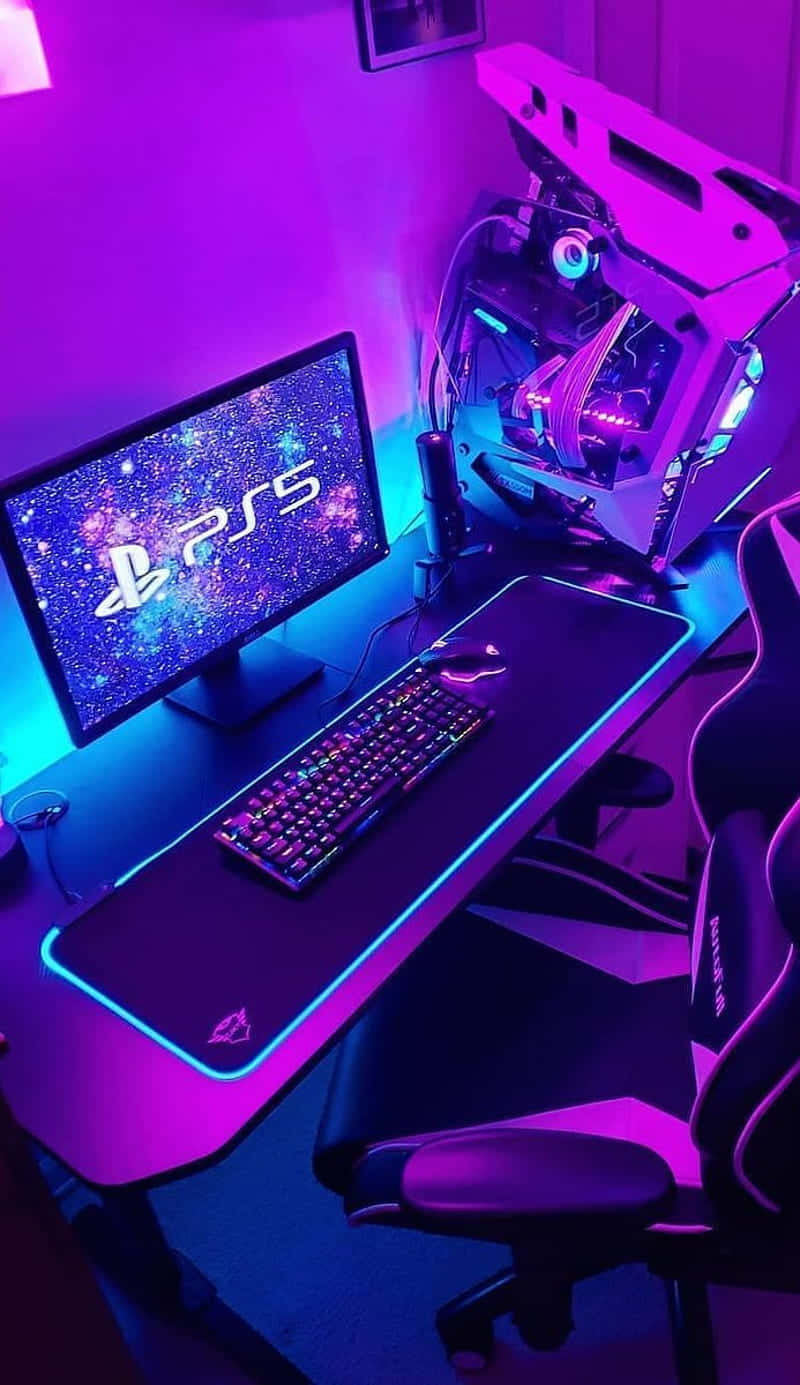 Gaming Pc Setup 桌布 壁紙 — 一個發光的遊戲設置，配備PS5顯示器、鍵盤和RGB燈效的PC主機，沐浴在紫色和藍色的霓虹燈光中。