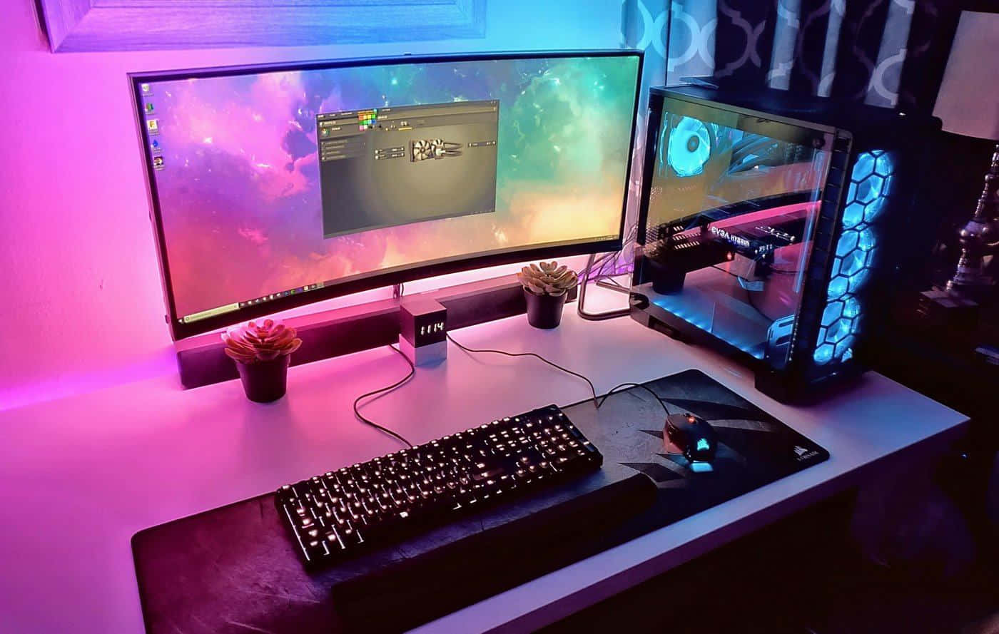 Gaming Pc Setup 桌布 壁紙 — 一個發光的遊戲設置，配備曲面顯示器宇宙風格壁紙和透明PC機箱，在白色桌子上以藍色LED燈照亮。