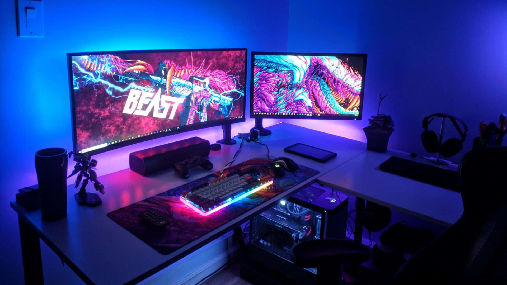 1920 X 1080 HD Gaming 桌布 壁紙 — 一個發光的遊戲設置，配備雙顯示器，顯示沐浴在藍色環境光中的鮮豔數位藝術。