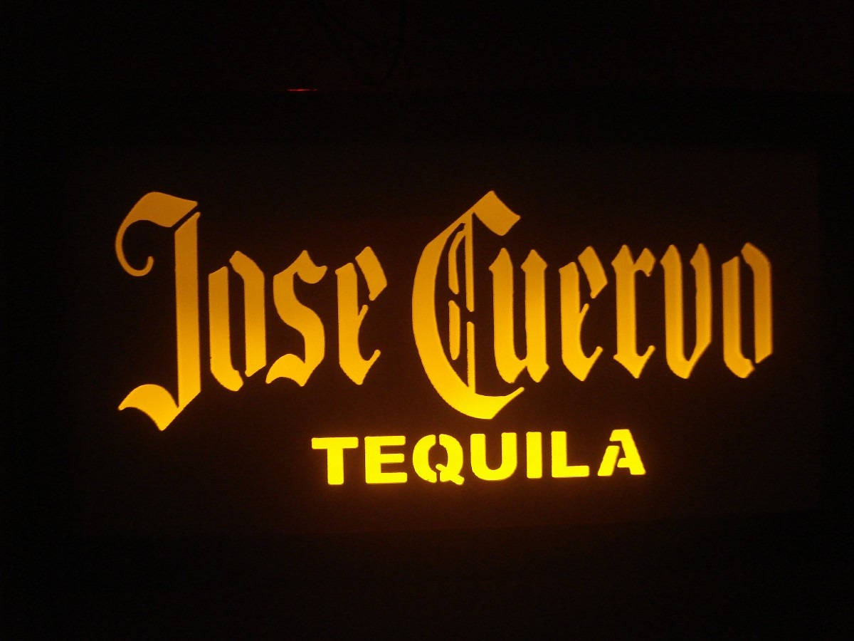 標誌 桌布 壁紙 — 一個發光的金色 Jose Cuervo Tequila 標誌在昏暗的環境中照亮了黑暗的背景。