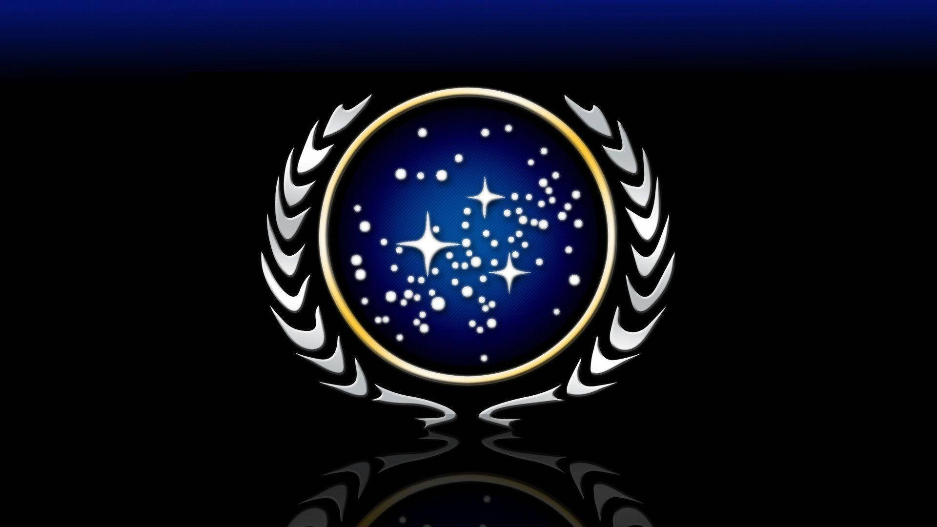 星際爭霸戰 桌布 壁紙 — 一個發光的金色圓形徽章，帶有星形圖案和銀色月桂花環，背景為深藍色漸變並帶有反射。