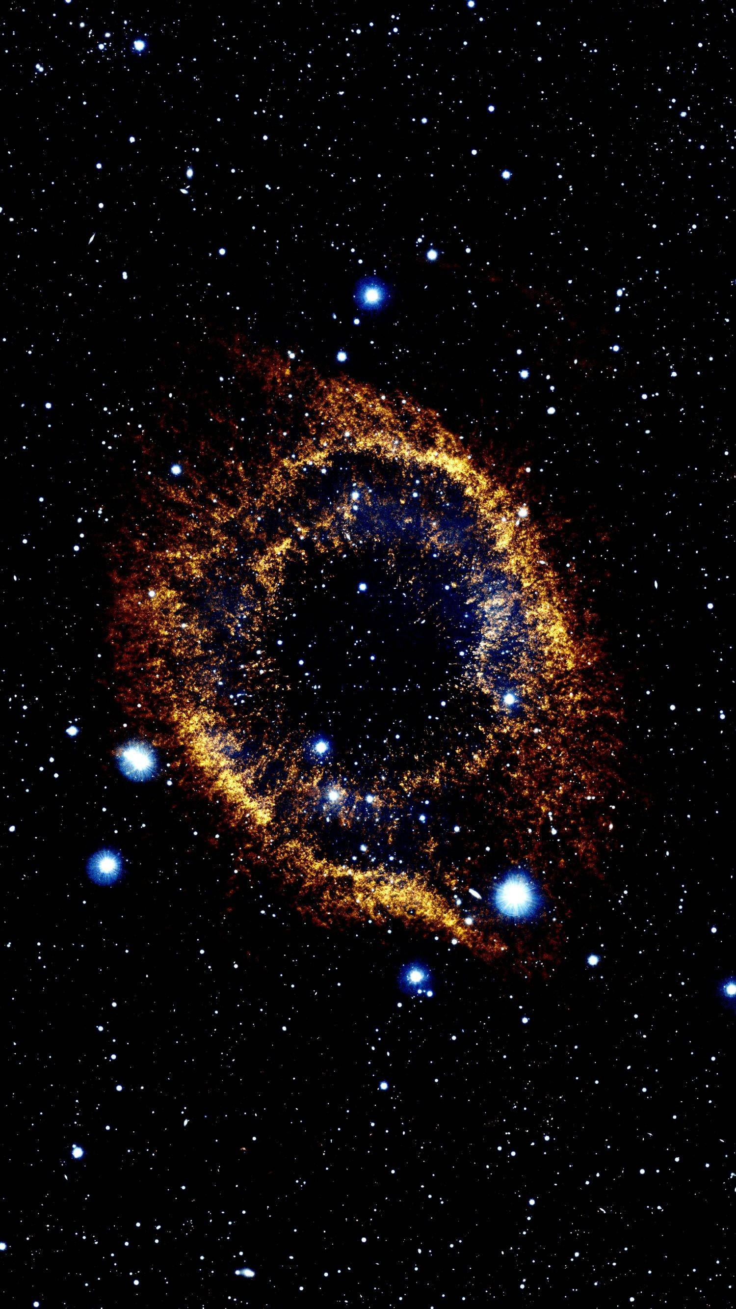 AMOLED 桌布 壁紙 — 一個發光的金色環狀星雲在星空中旋轉，明亮的藍色星星散落在黑色虛空中。
