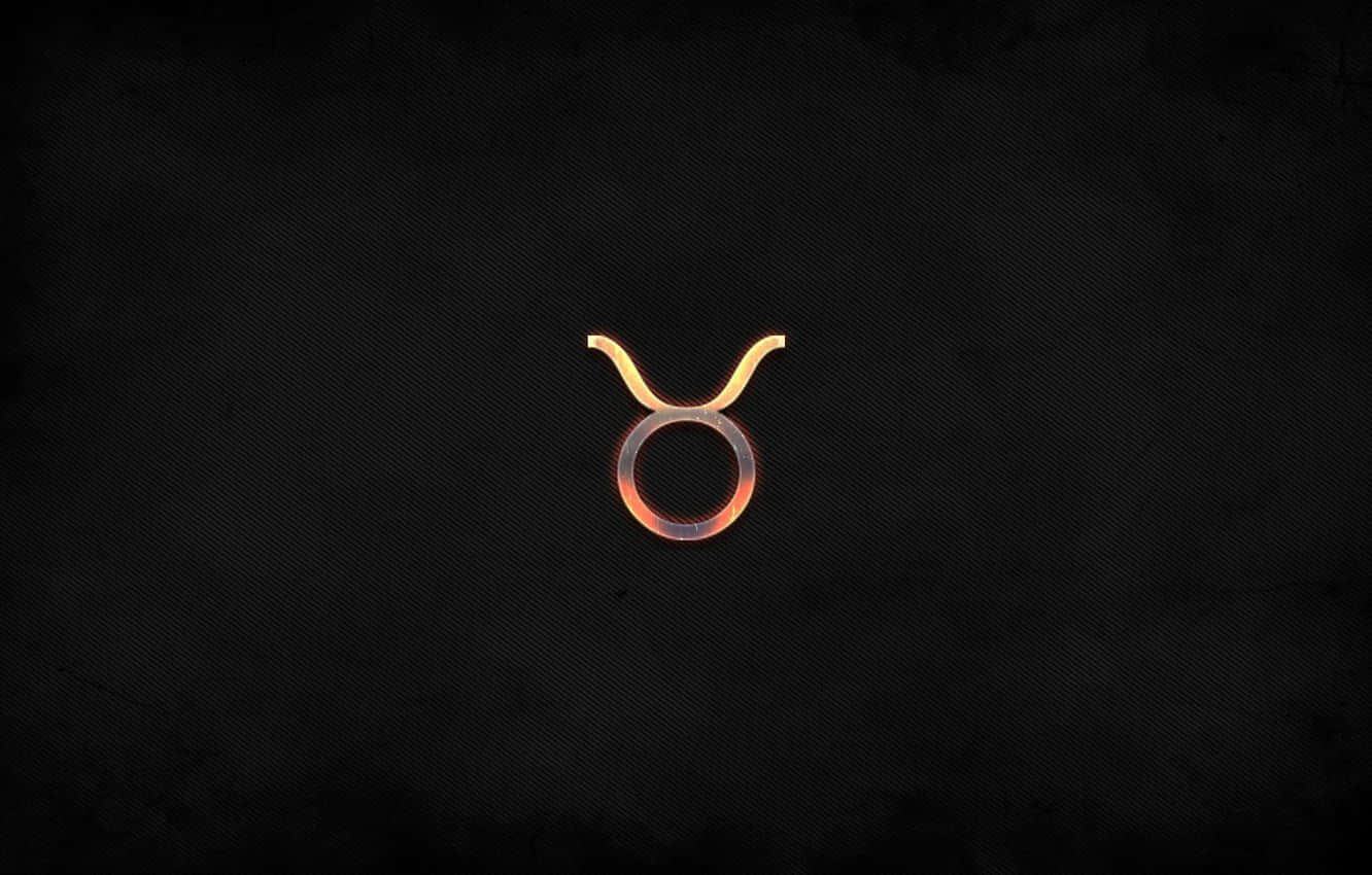 taurus 桌布 壁紙 — 一個發光的金色金牛座星座符號，居中於帶有細微漸變照明的紋理深色背景上。