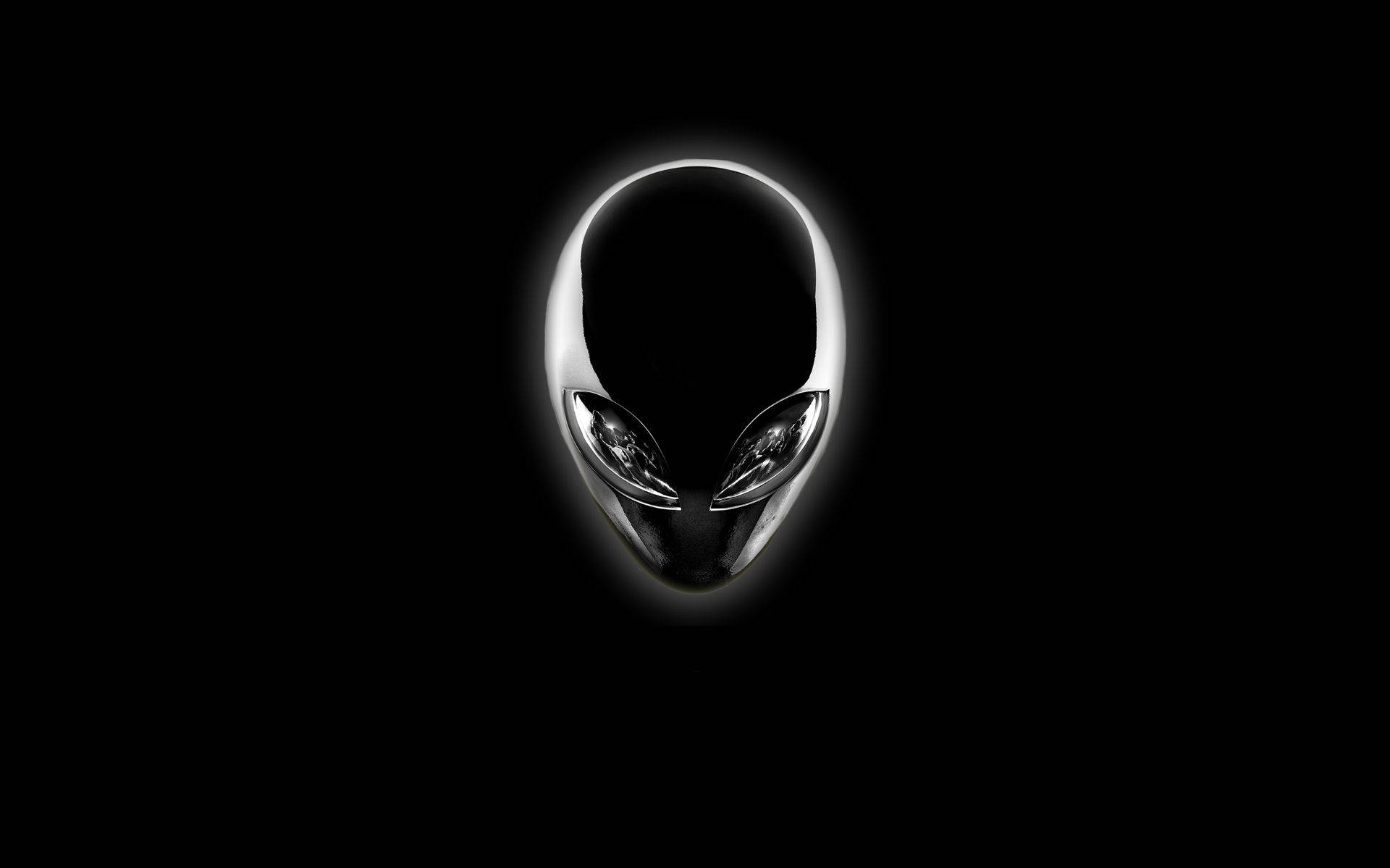 外星人 桌布 壁紙 — 一個發光的銀色外星人頭標誌，居中於純黑色背景上，帶有柔和的光暈。