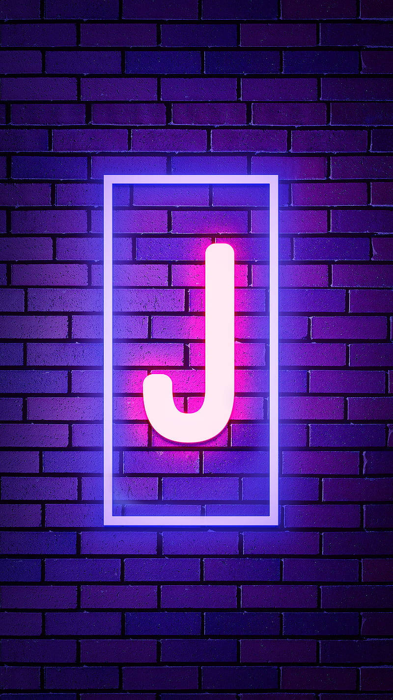 J 桌布 壁紙 — 一個發光的霓虹字母J，以粉紅和藍色調在深紫色磚牆上投射出鮮豔的光芒。