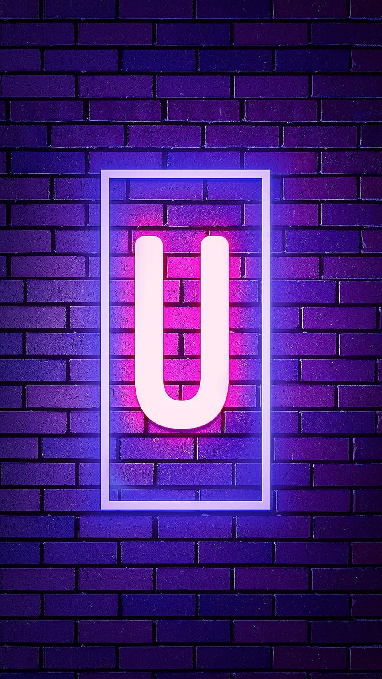 U 桌布 壁紙 — 一個發光的霓虹字母U，在粉紅色和藍色光中，由一個矩形框在深紫色磚牆上。