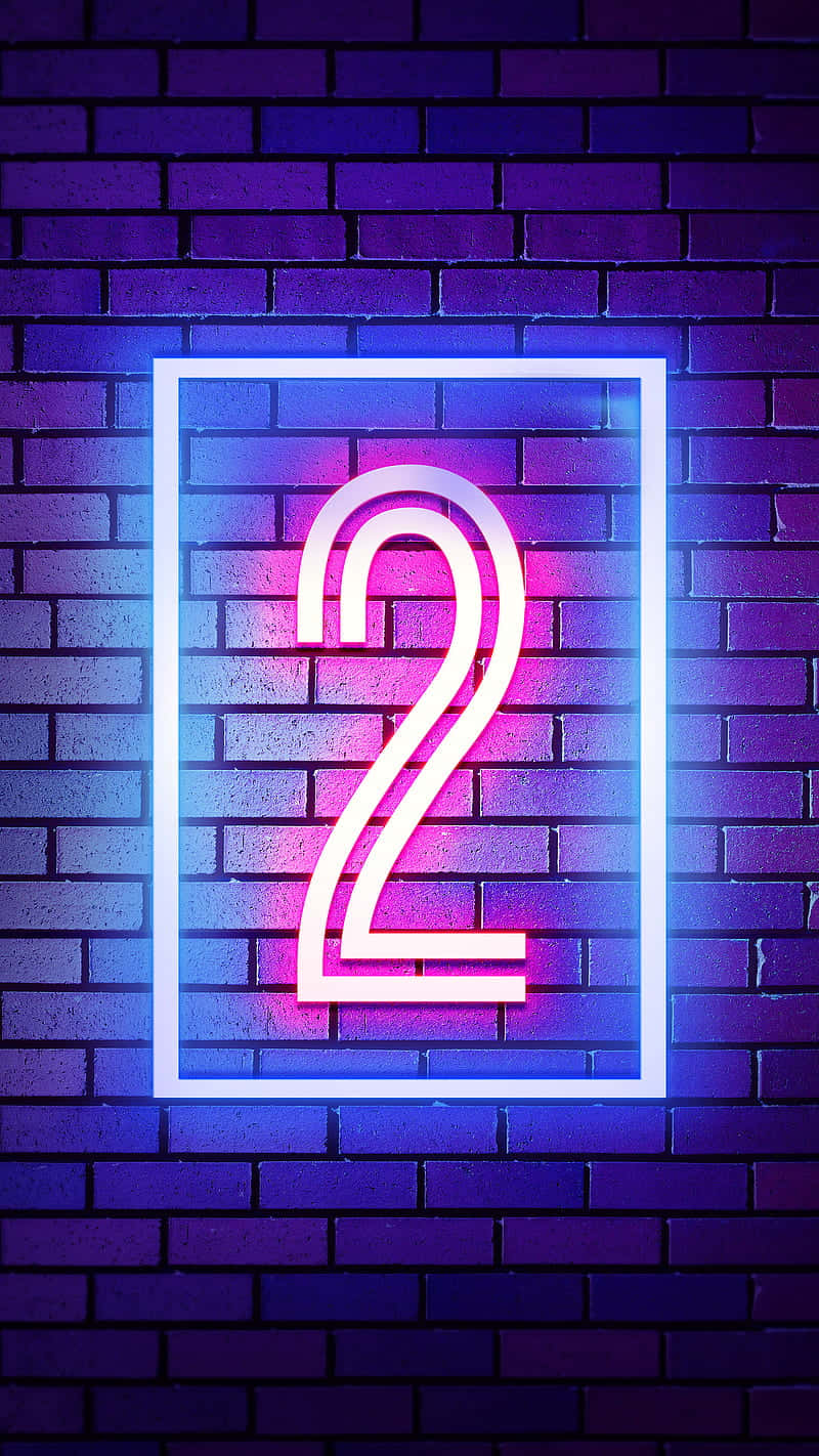 Numbers 桌布 壁紙 — 一個發光的霓虹數字二，帶有粉紅色和藍色光芒，被白色邊框框在深色磚牆上。