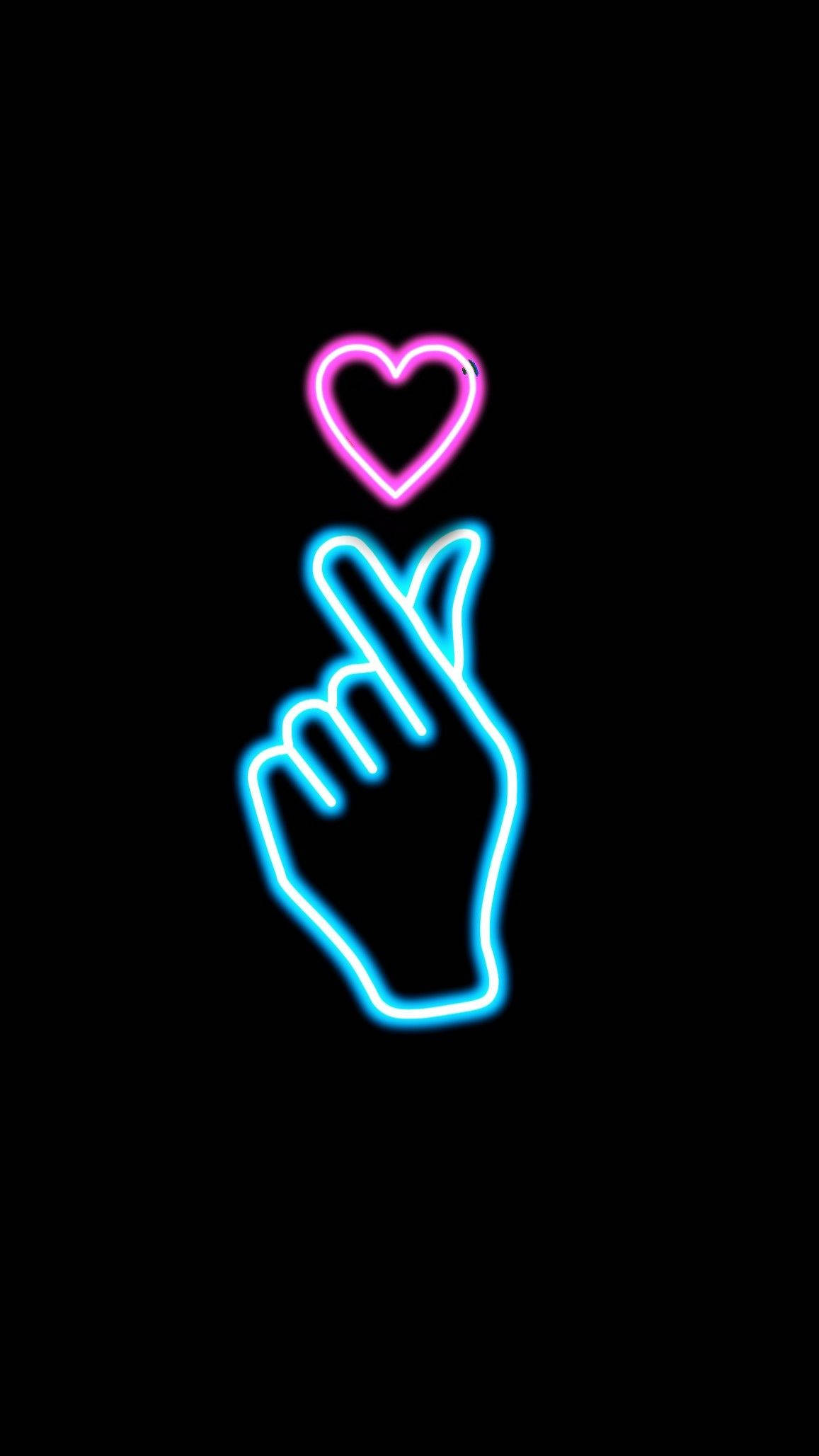Finger Heart 桌布 壁紙 — 一個發光的霓虹燈手勢，食指指向黑色背景上的一個粉紅色心形。