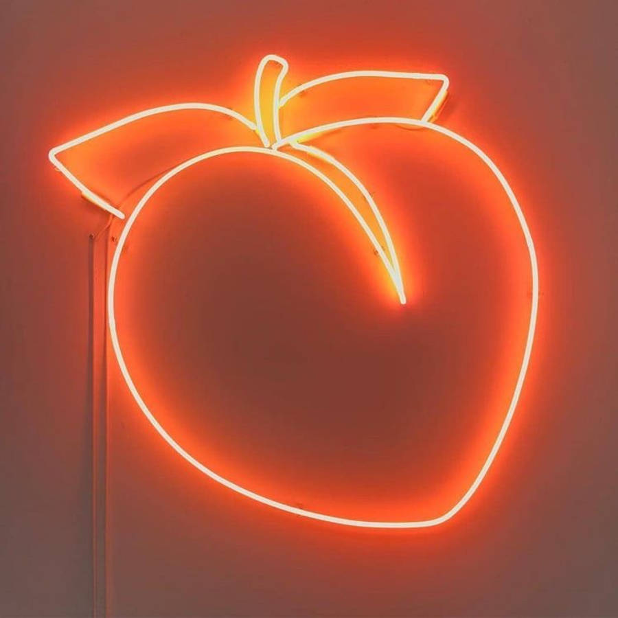 Fruit 桌布 壁紙 — 一個發光的霓虹燈桃子標誌，在柔和的牆壁上投射出溫暖的橙色光芒，其明亮的輪廓營造出復古懷舊的氛圍。