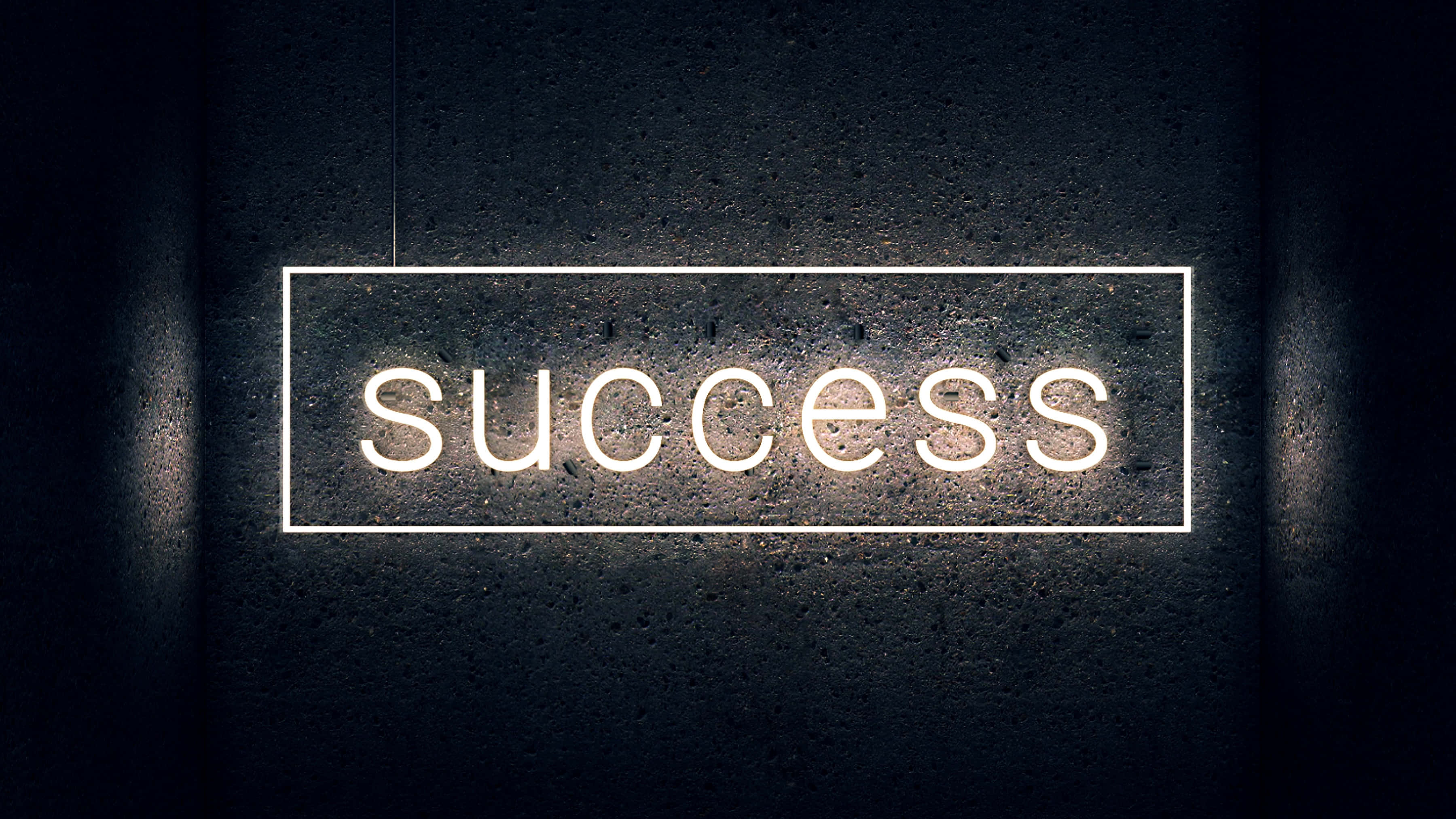 Success 桌布 壁紙 — 一個發光的霓虹燈牌，拼寫出成功，掛在昏暗空間中一面深色紋理牆上。