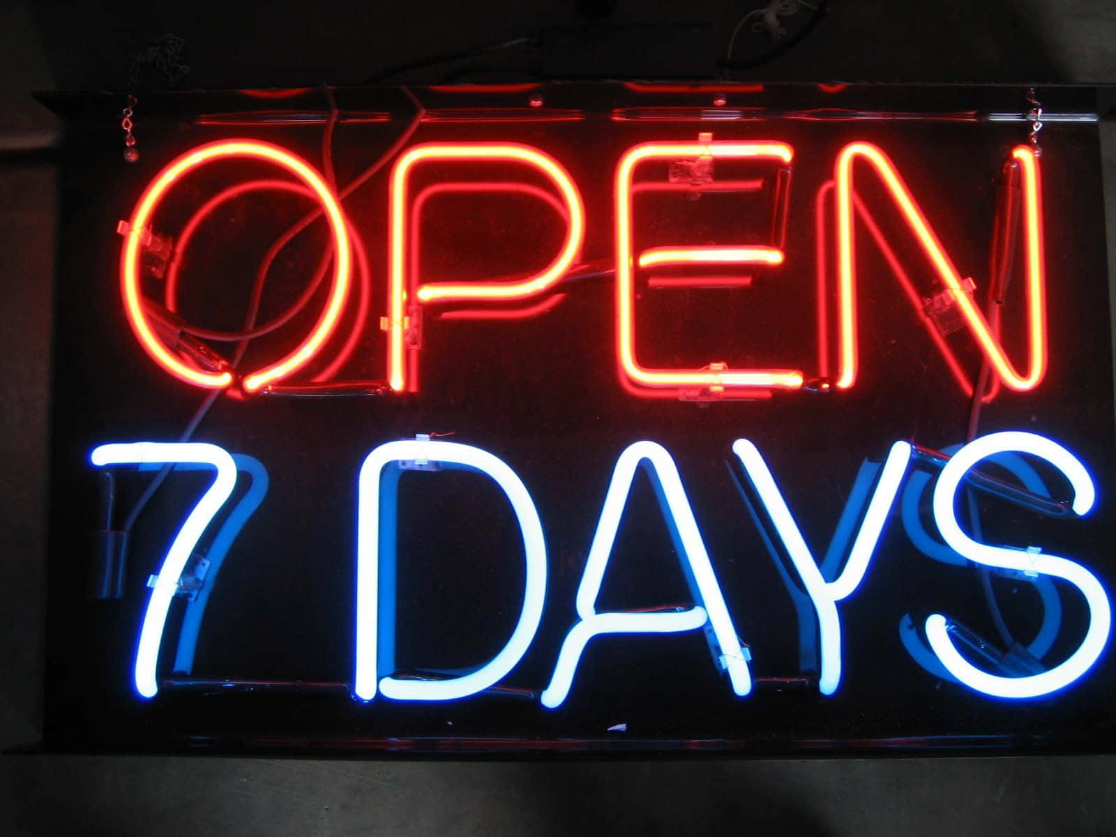 nightlife 桌布 壁紙 — 一個發光的霓虹燈牌寫著「OPEN 7 DAYS」，以粗體紅色和藍色字體在深色背景上。